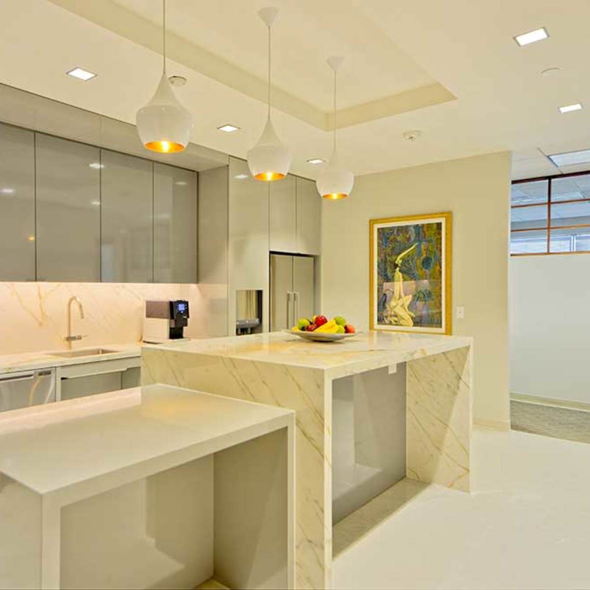 A modern kitchen with sleek gray cabinets, a marble island, and pendant lighting above the countertop.