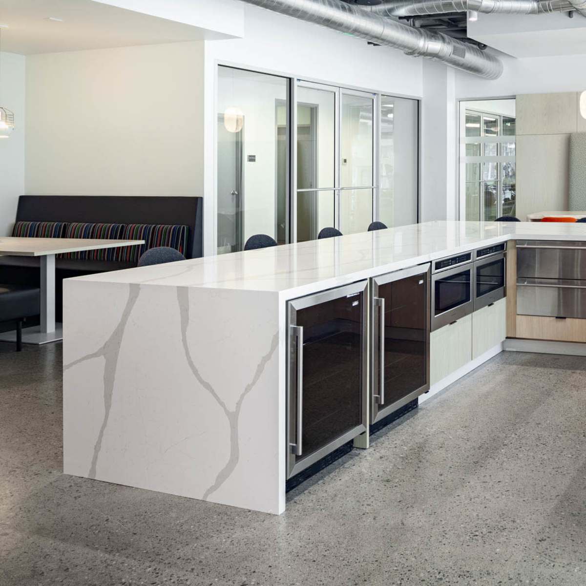 A modern kitchen with a large island, equipped with sleek cabinetry, a sink, and stainless steel appliances.