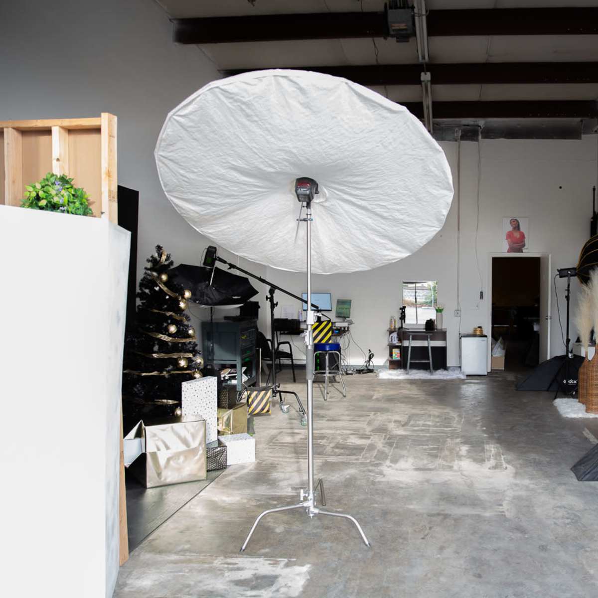 A photography studio with lighting equipment, backdrops, and props arranged in a spacious, minimally decorated area.