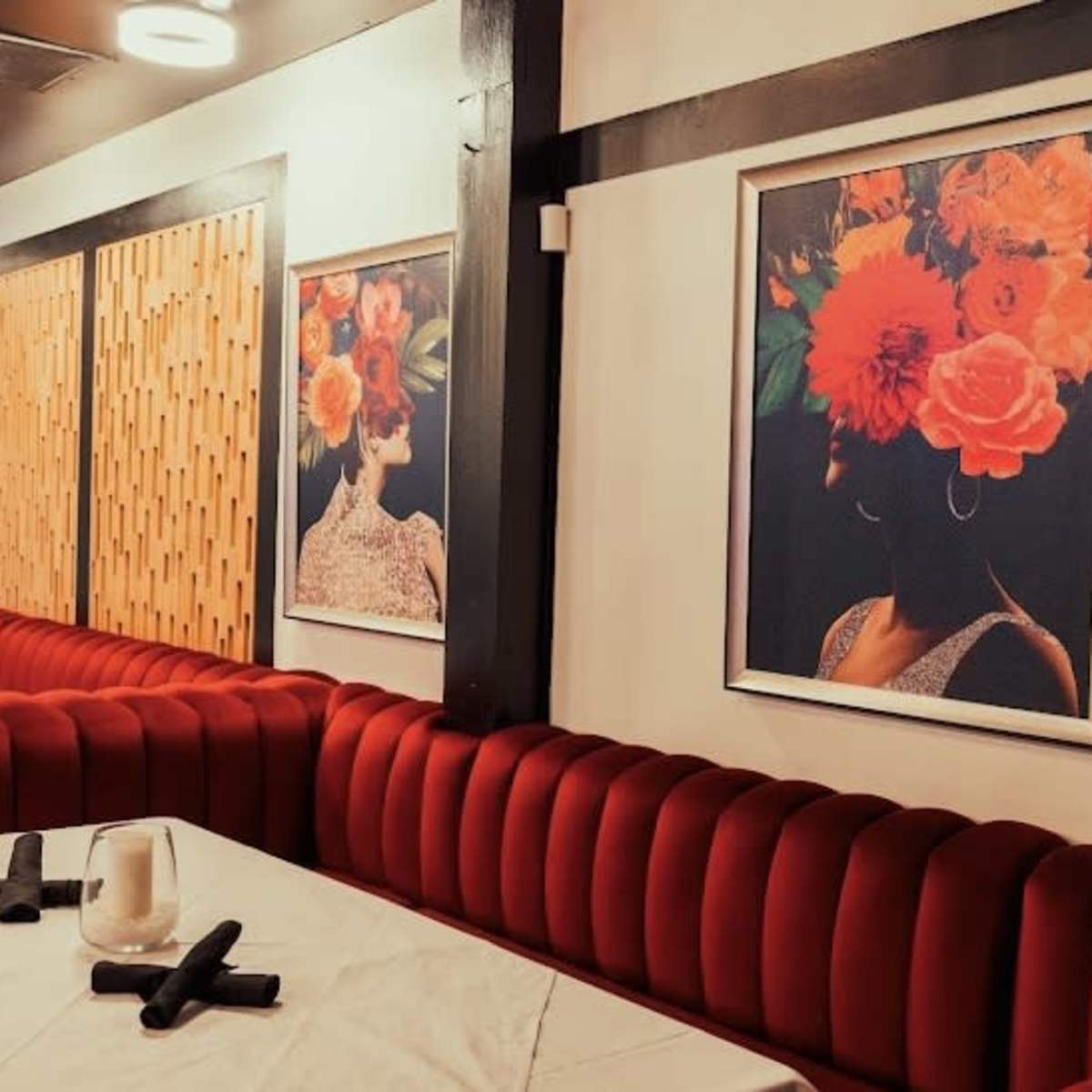The scene features a restaurant interior with red velvet seating and framed floral portrait artworks on the walls.