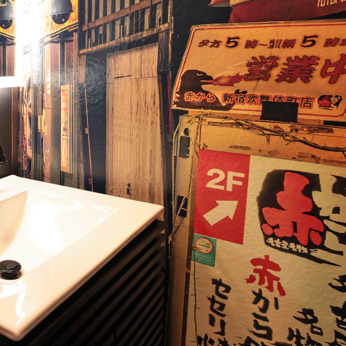 A modern sink set against a backdrop of vintage-style signs and wooden paneling.