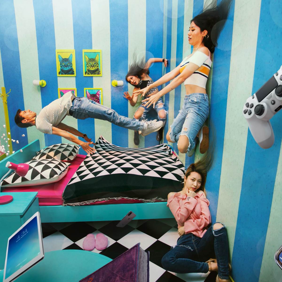 A group of young people appears to be floating in an upside-down room decorated with colorful walls and modern furniture.