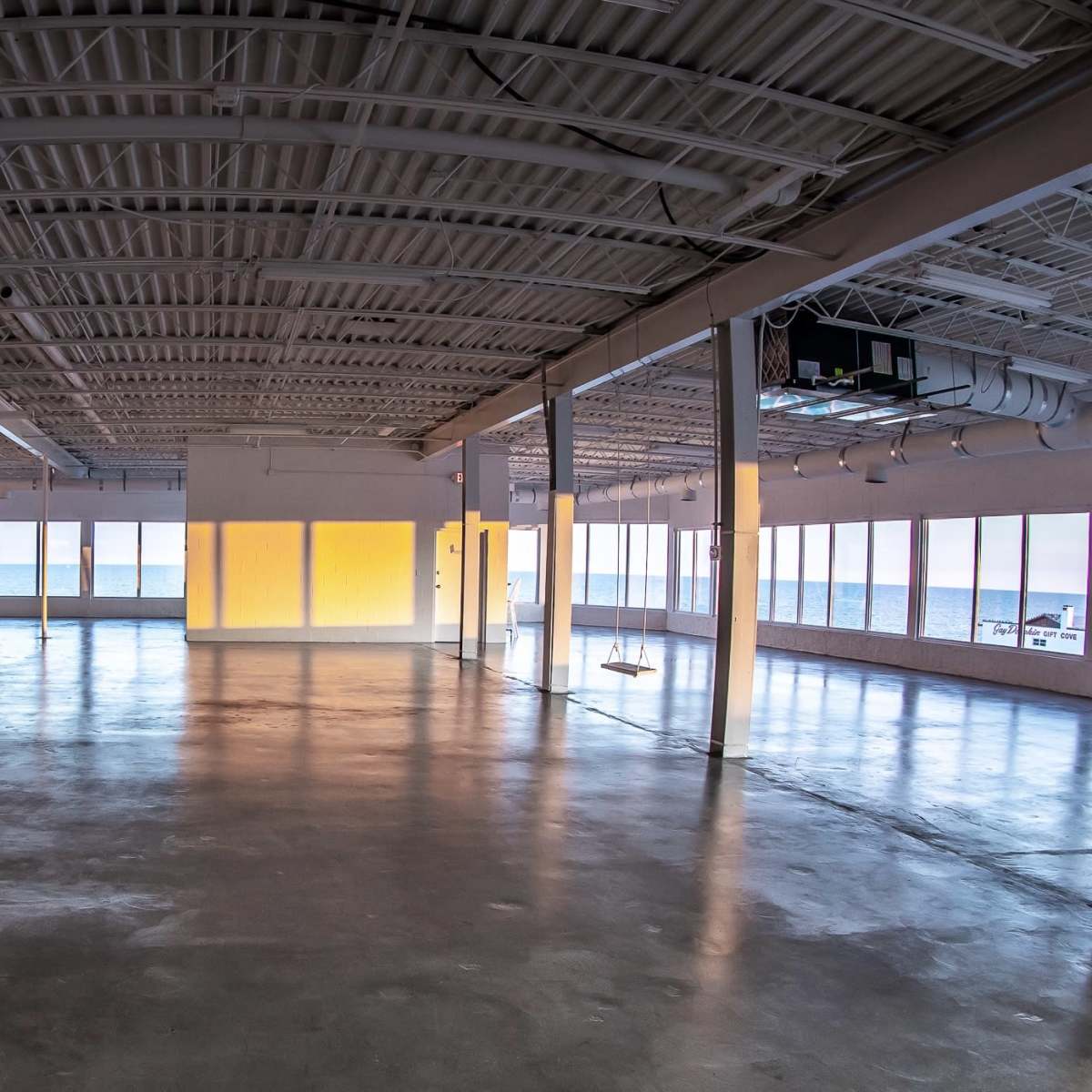 A spacious, empty interior of a modern building with large windows that let in natural light.