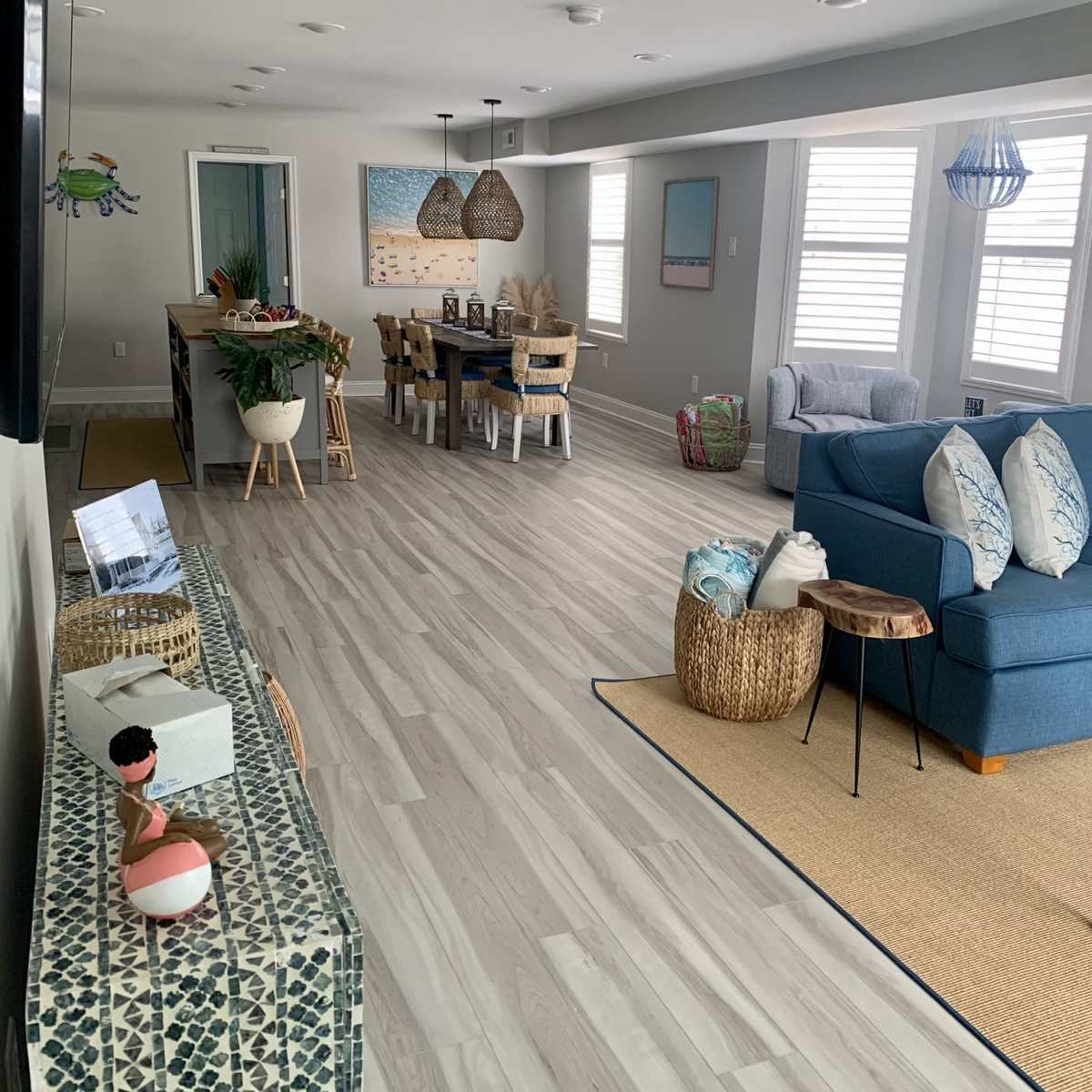 A modern, open-concept living area with a seating arrangement, a dining table, and decorative elements in a light-colored space.