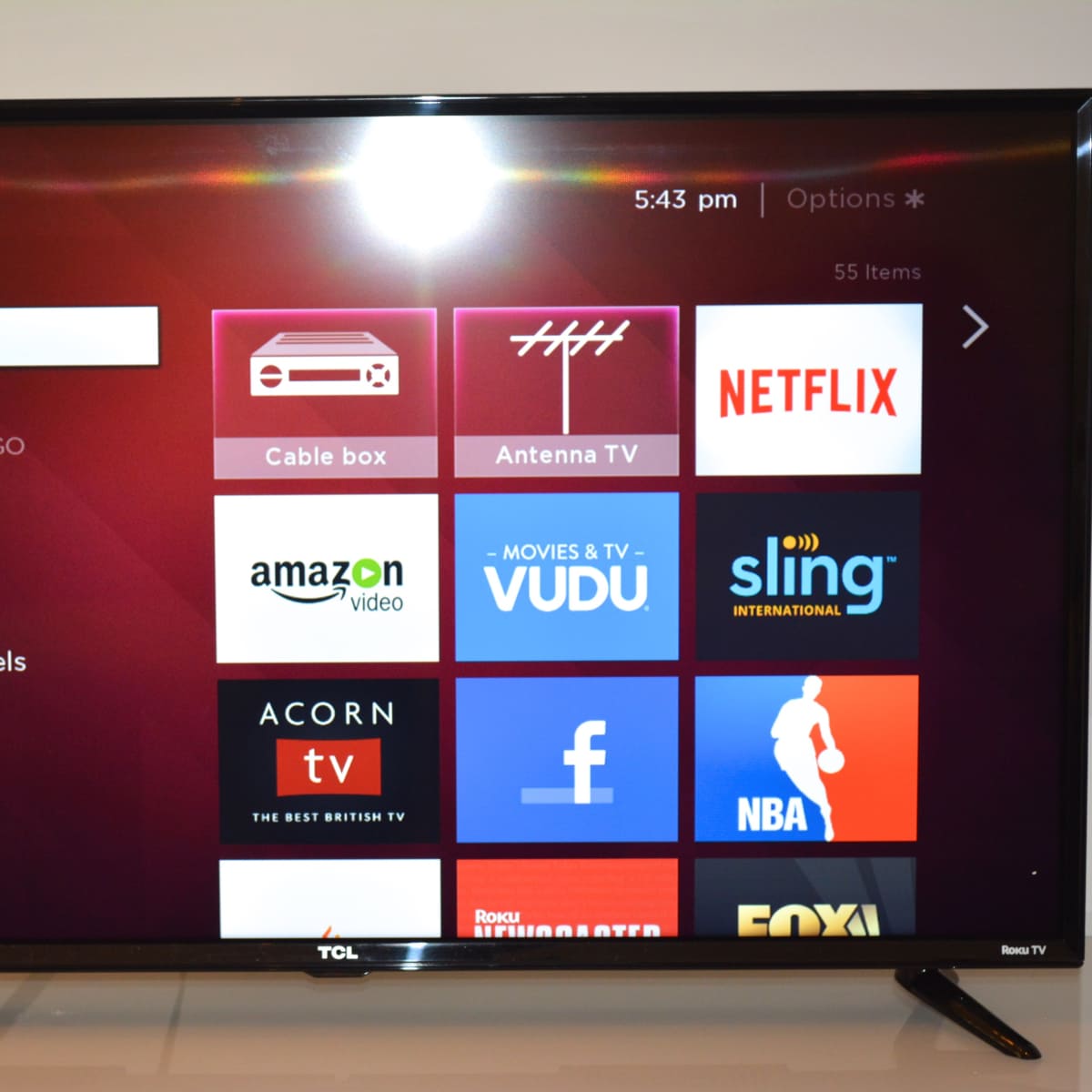 A TCL Roku TV displaying a menu screen with options for streaming services and settings.
