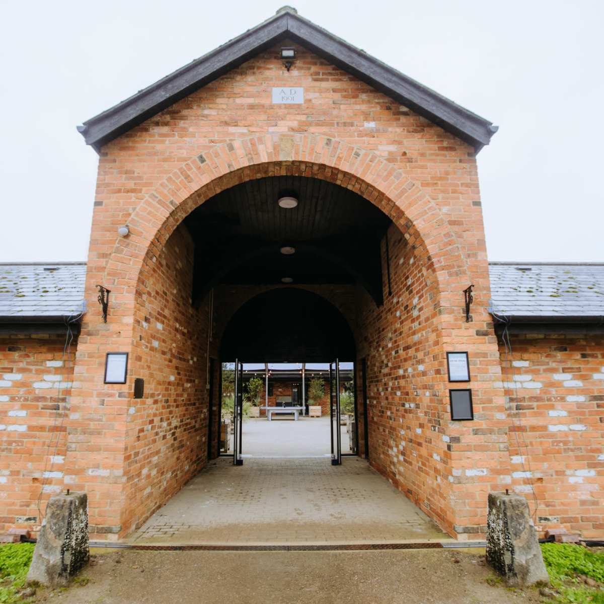 A brick building with a large arched entrance and a tiled roof.