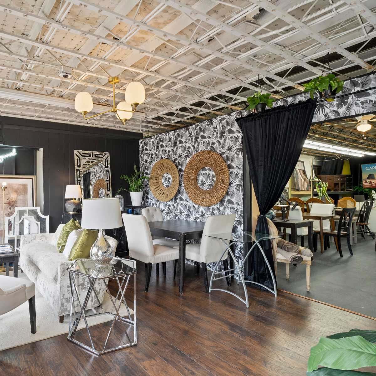 A modern interior design showroom featuring a mix of furnished seating areas, decorative wall textures, and various lighting fixtures.