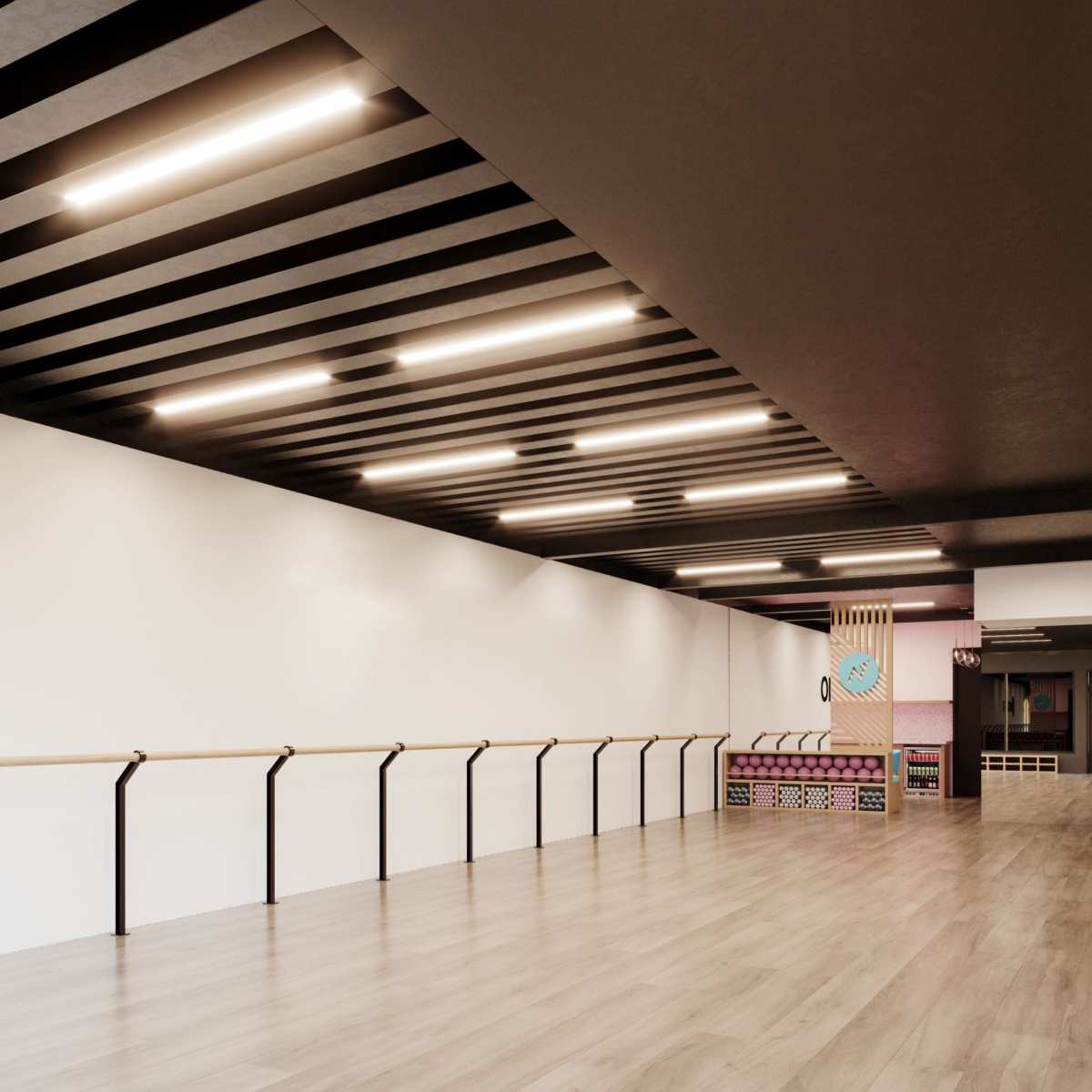 A spacious, empty dance studio with wooden floors, a ballet barre along one wall, and overhead lighting.