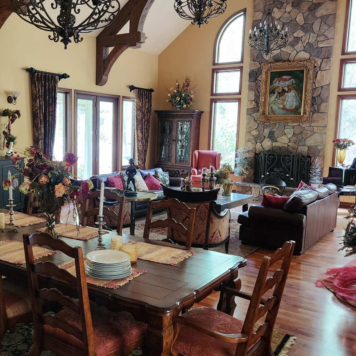 A spacious dining area with a large wooden table and chairs, adjacent to a cozy living room decorated for the holiday season.