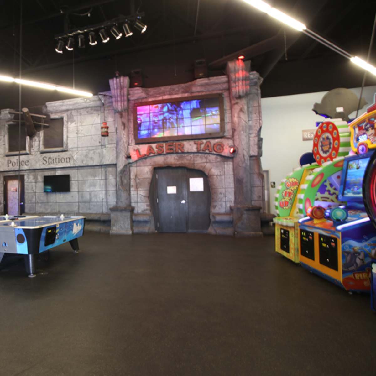 An entertainment venue with a laser tag area, arcade games, and a ping-pong table.