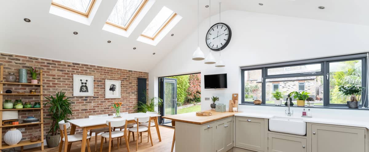 Large Vaulted Light Contemporary Kitchen Lounge Space with Aga and Brick Wall plus Traditional Lounge with Real Open Fire Place & Shuttered Windows in London Hero Image in undefined, London, 