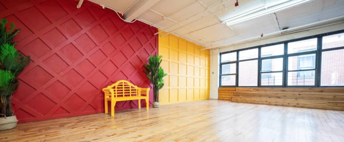 Artistic Photo Studio with Bright Red & Yellow walls, large framed windows, wooden floors and steps - Astoria 2 in Astoria Hero Image in Astoria, Astoria, NY