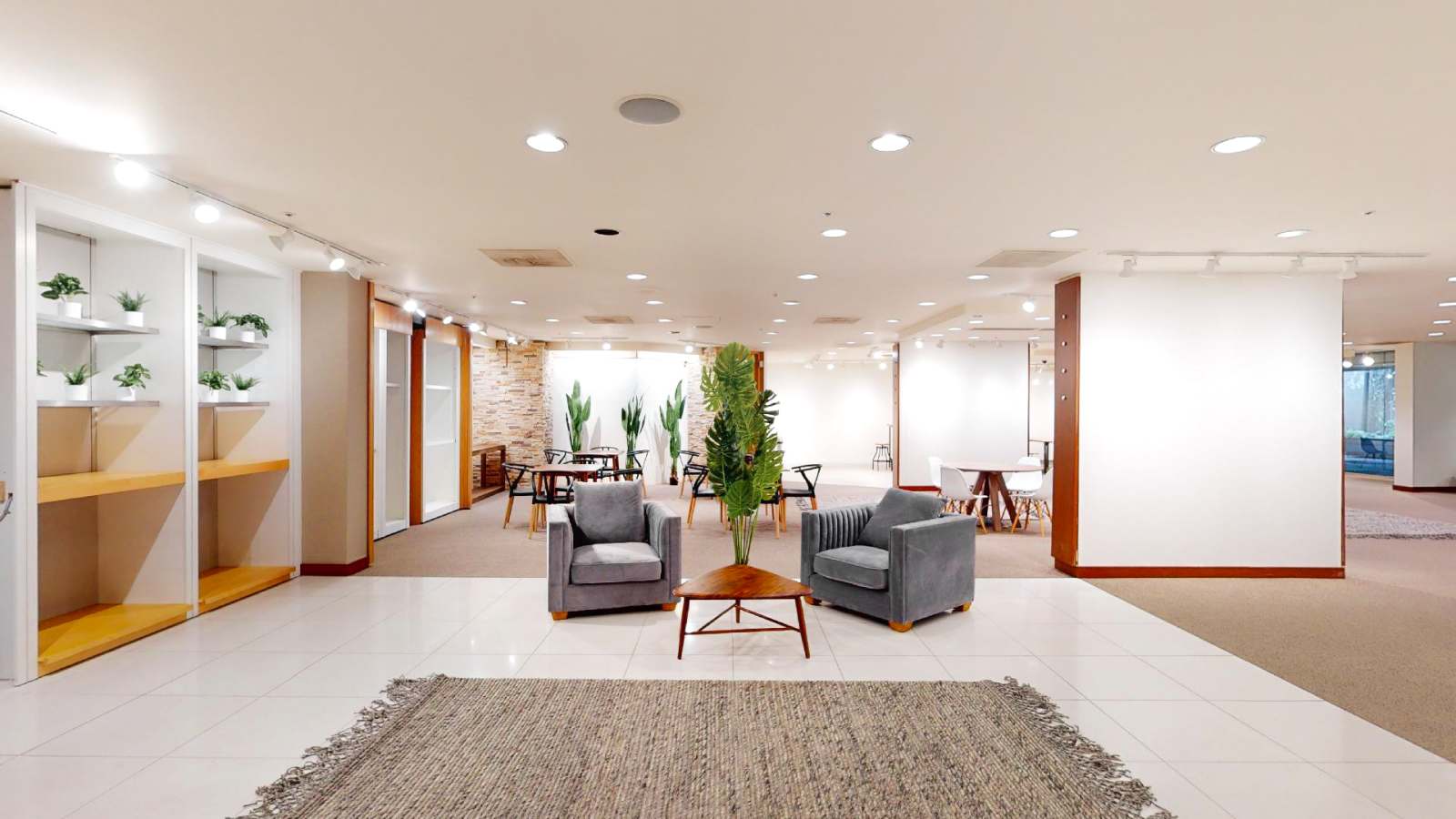 Open modern event floor with seating areas, tables, and plants