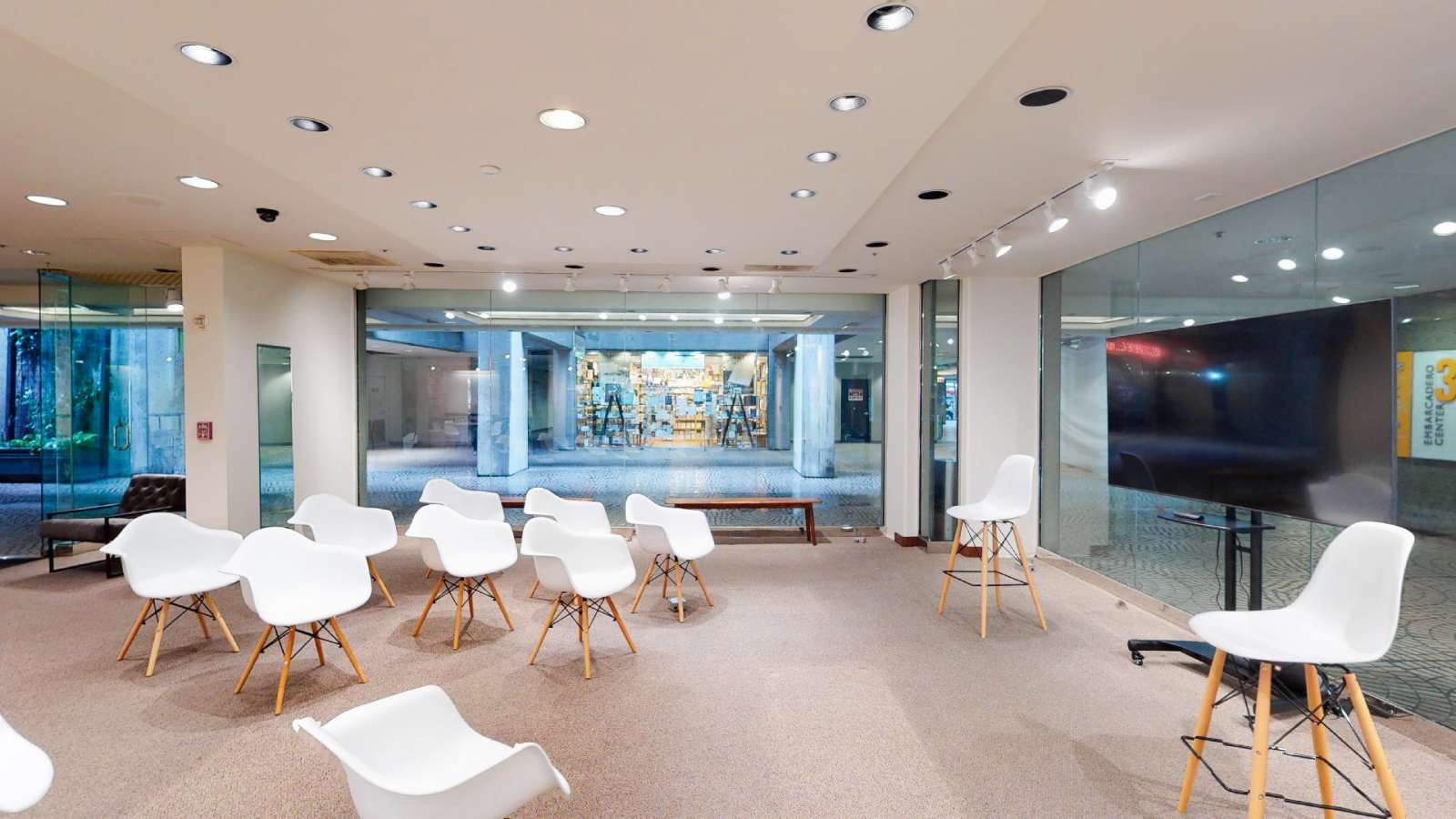 Meeting room with white chairs arranged toward a presentation screen