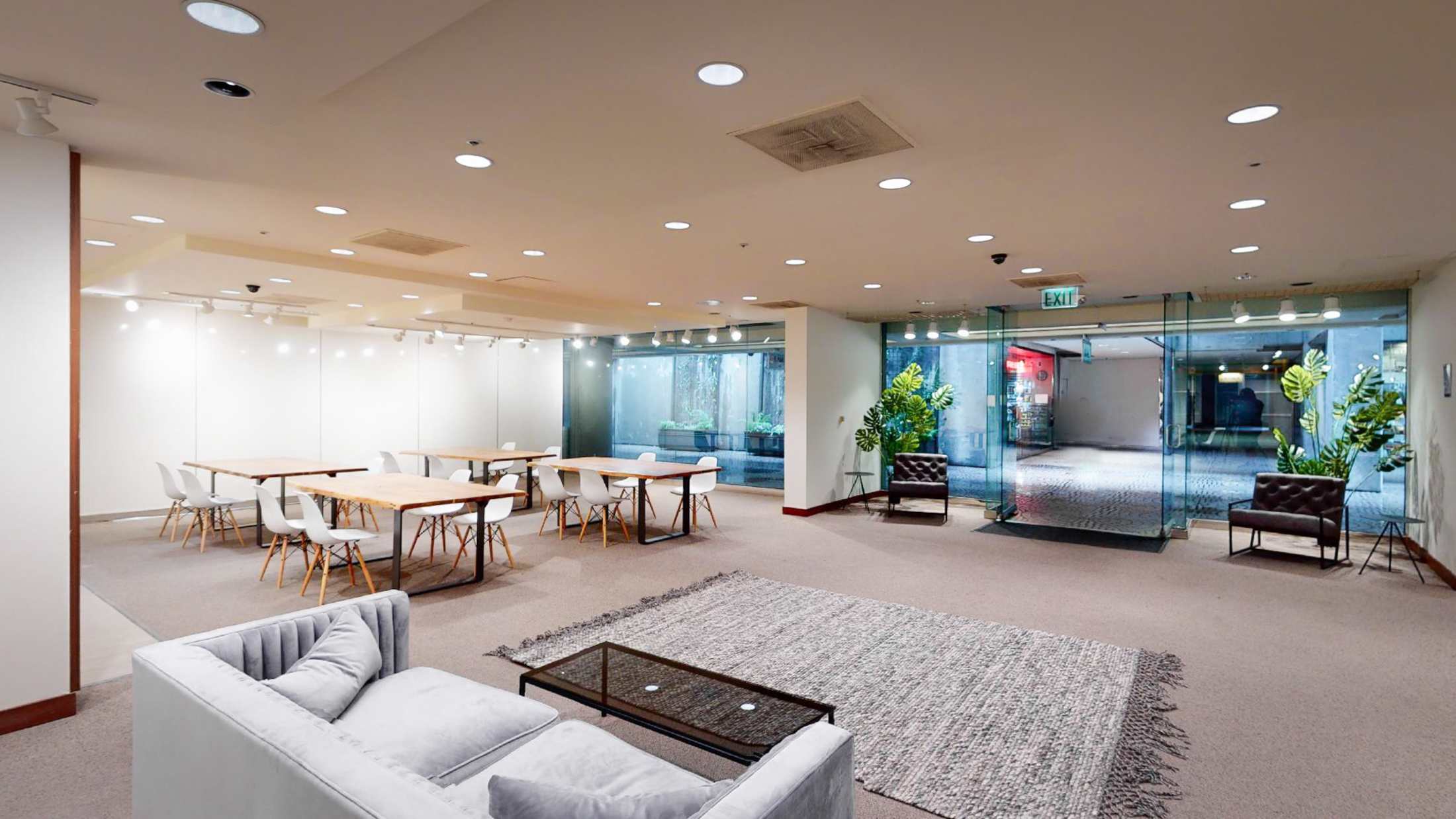 Modern downtown event space with tables, lounge seating, and glass doors