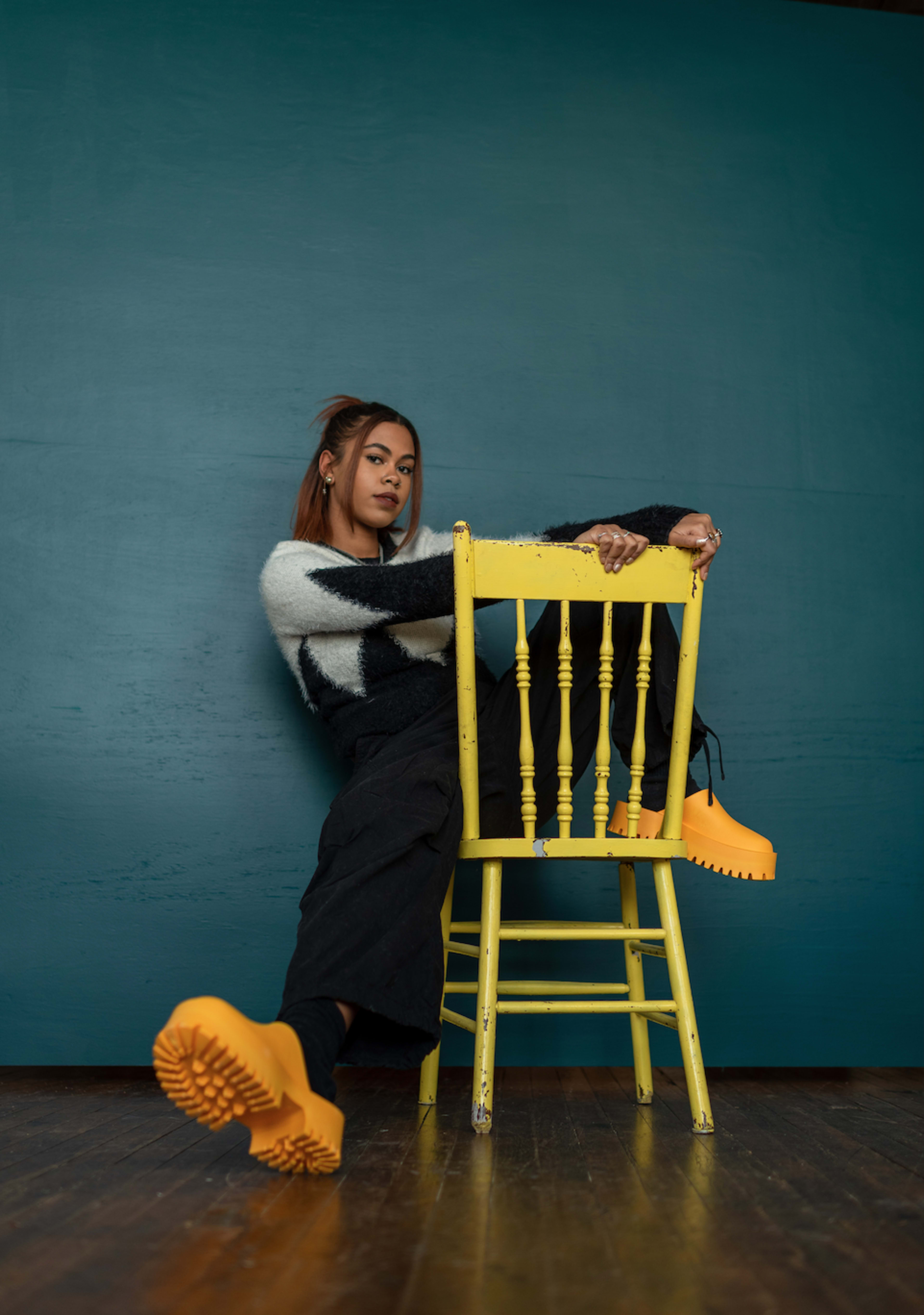 Une femme assise sur une chaise jaune.