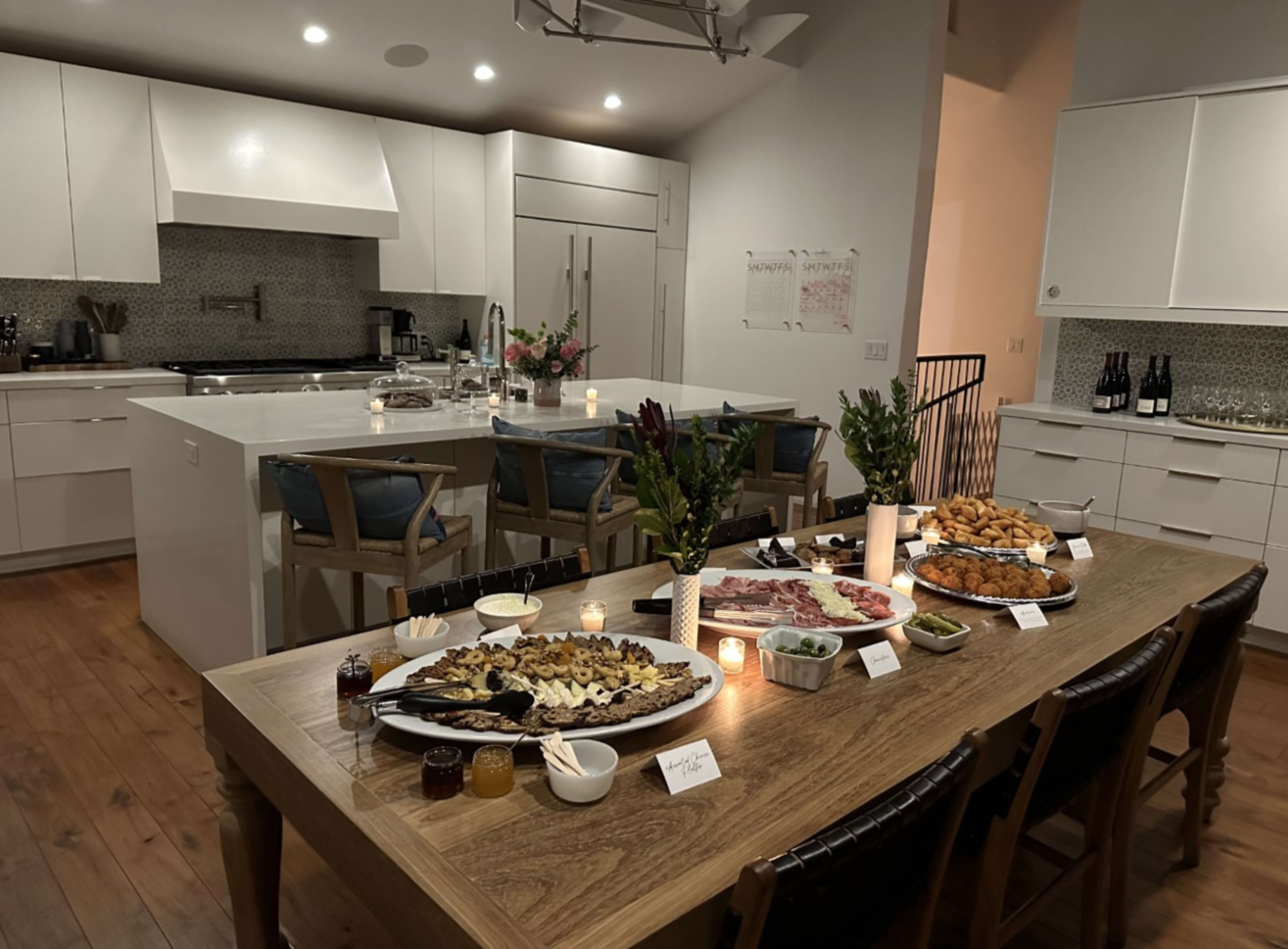 A rustic table with plates of food on it in a kitchen.