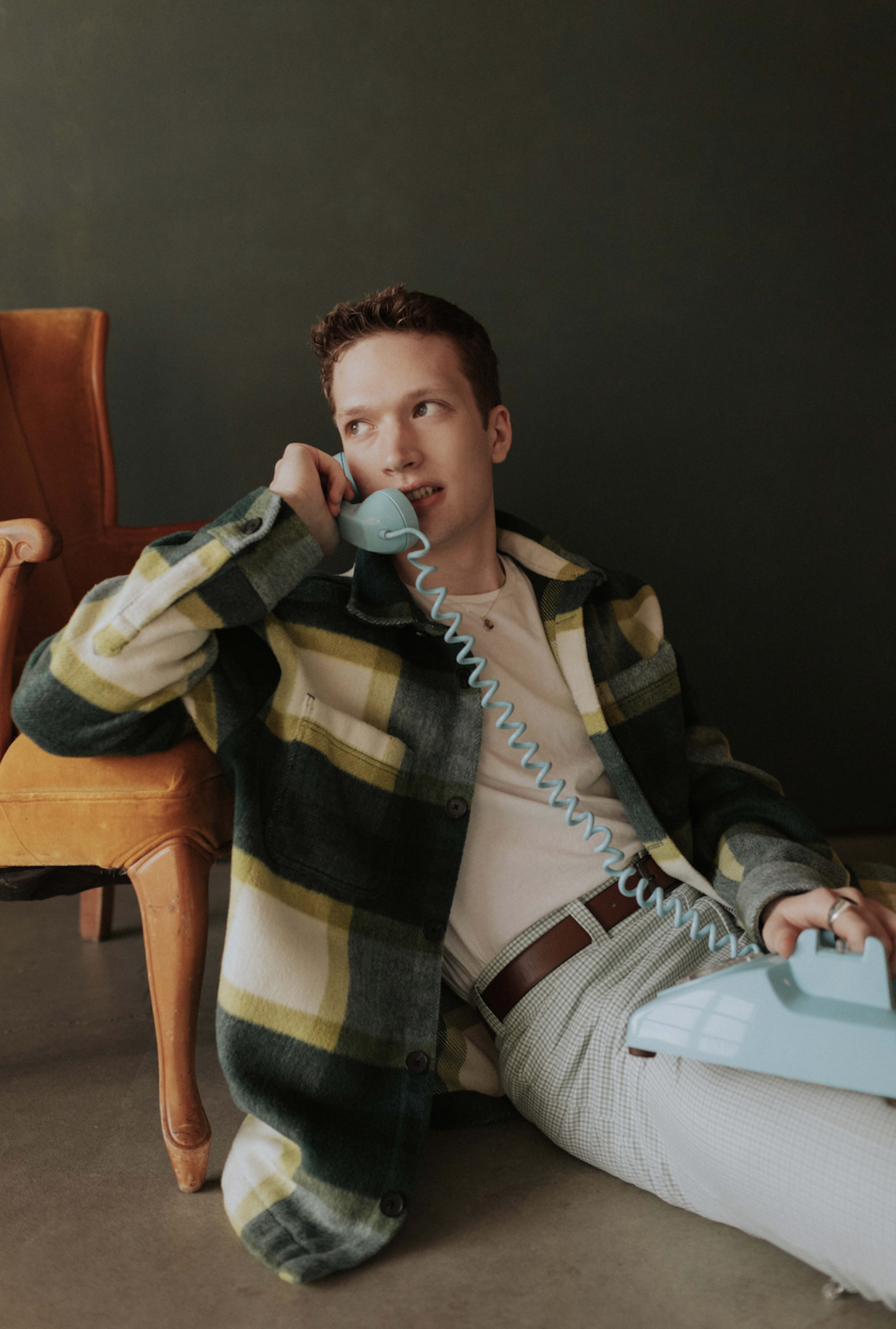 Un homme posant avec un téléphone pour un shooting photo rétro.