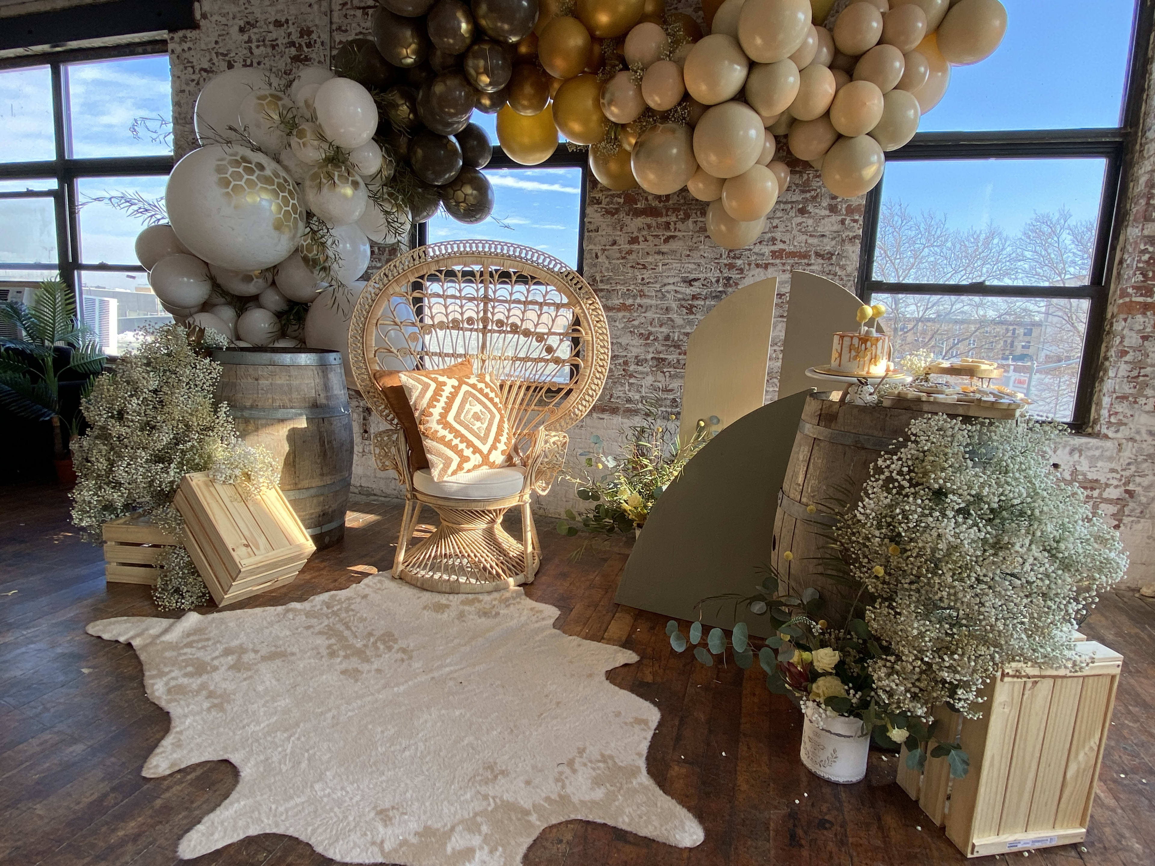 Una habitación de inspiración boho llena de globos beige y una silla para un baby shower.