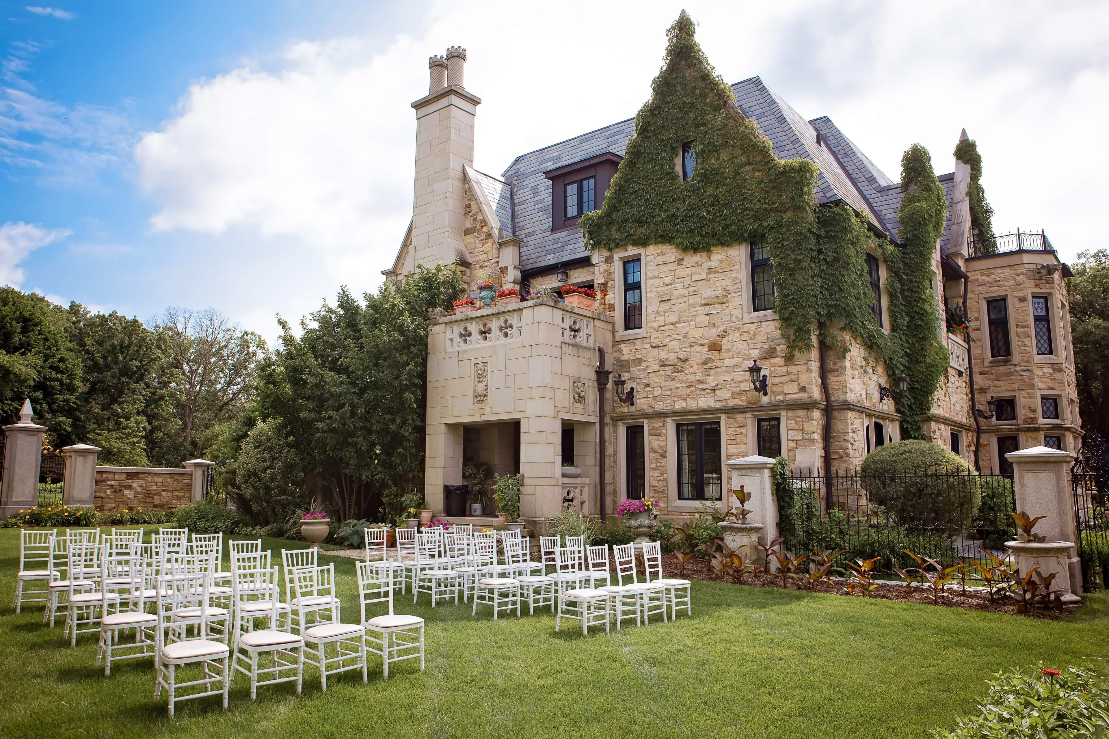 Chairs on a green lawn in front of a brown building.