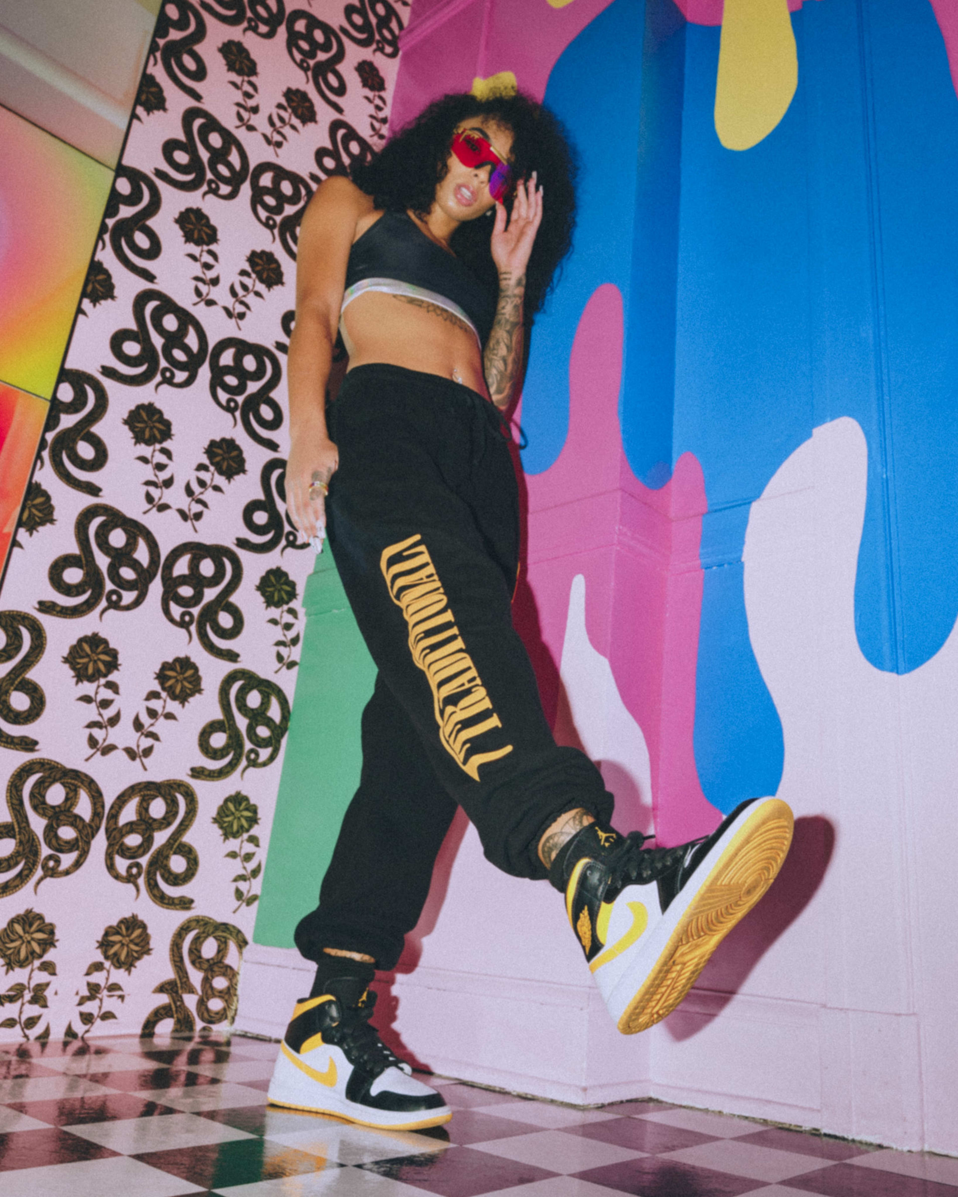 A fashion photoshoot with a woman standing on a checkered floor.