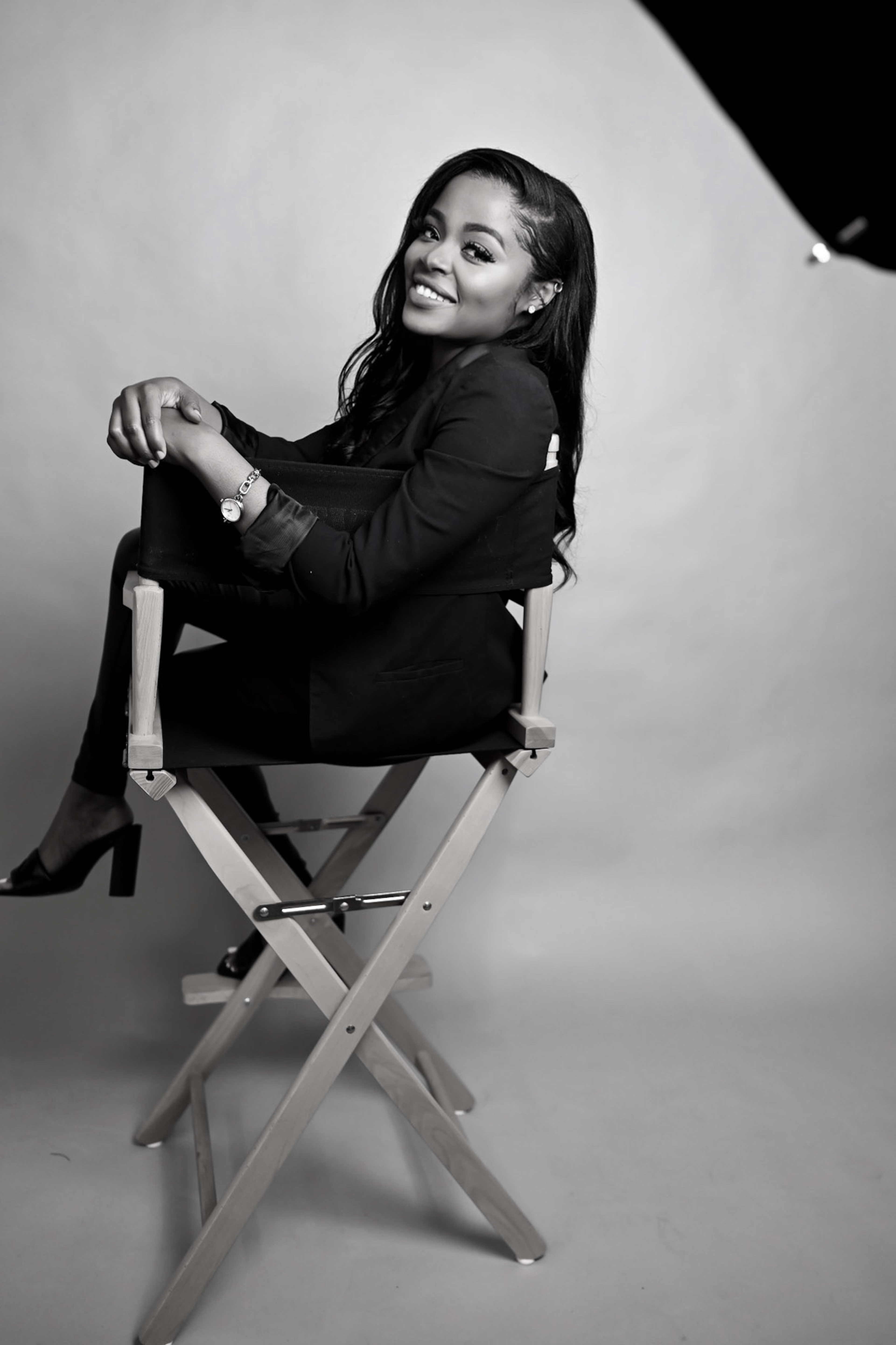 A black and white portrait of a woman in a chair.