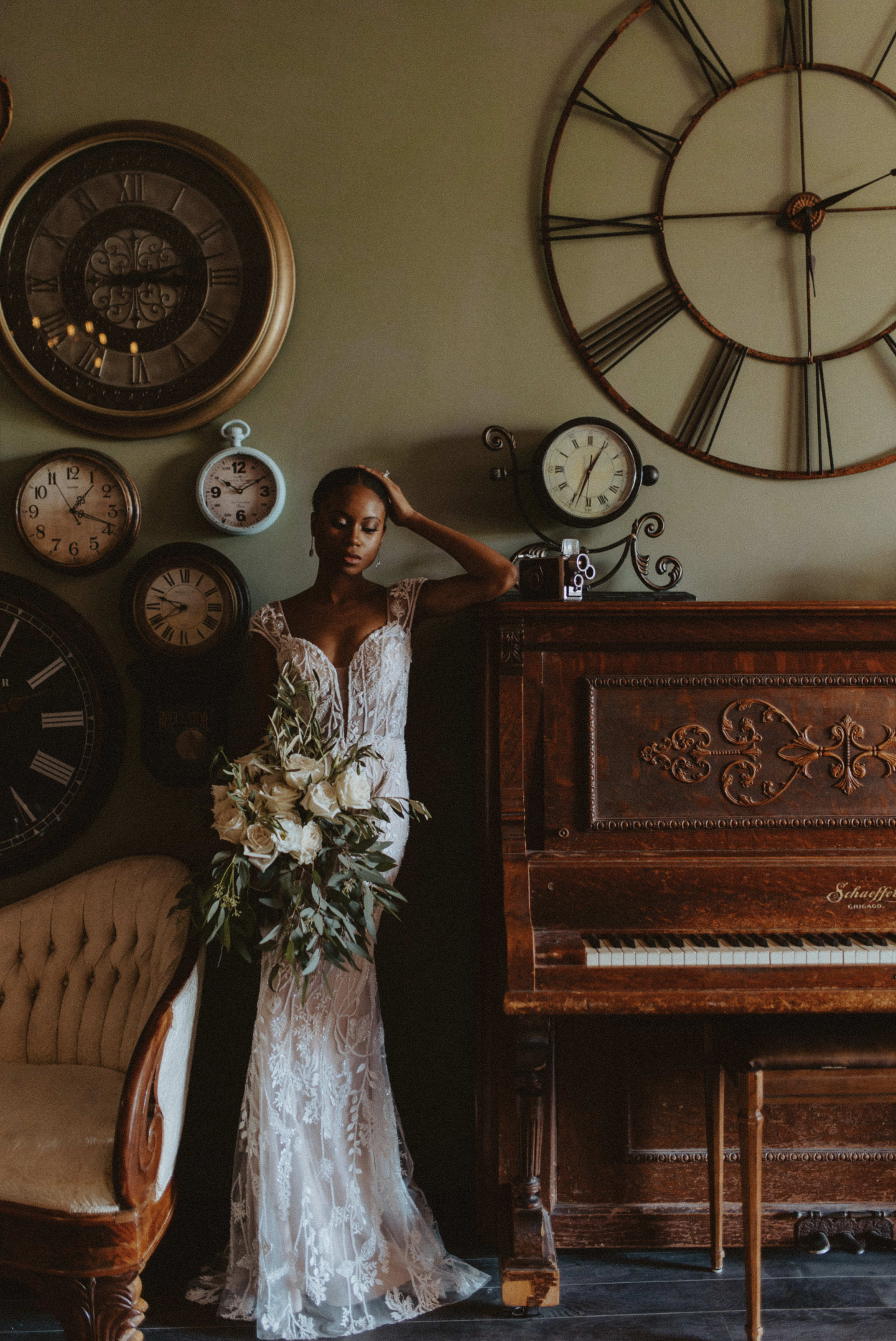 A rustic photoshoot featuring a woman in a wedding dress posing next to a piano surrounded by clocks.