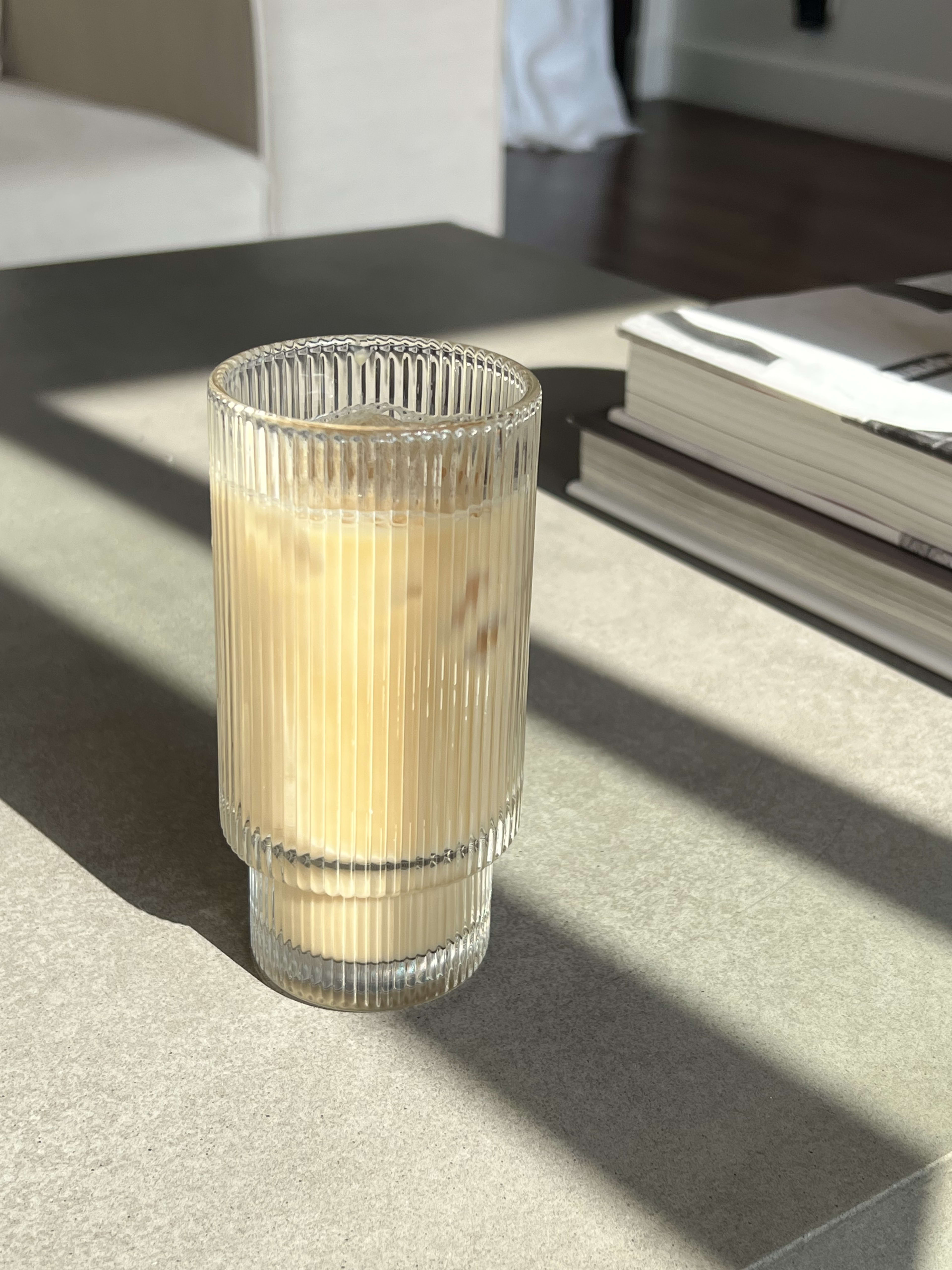 A glass of coffee on the coffee table photographed in close up.