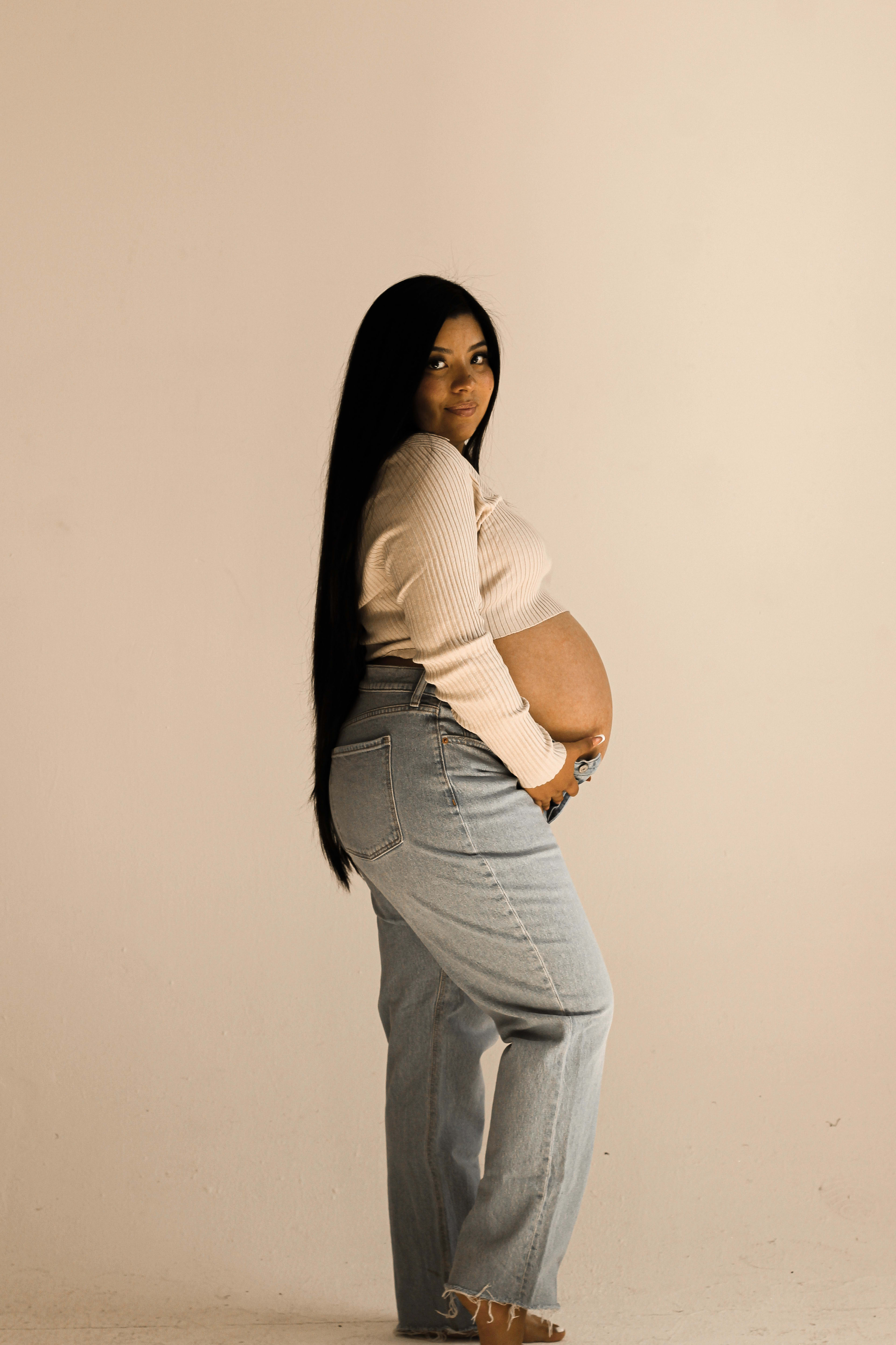 A beige maternity photoshoot of a pregnant woman.