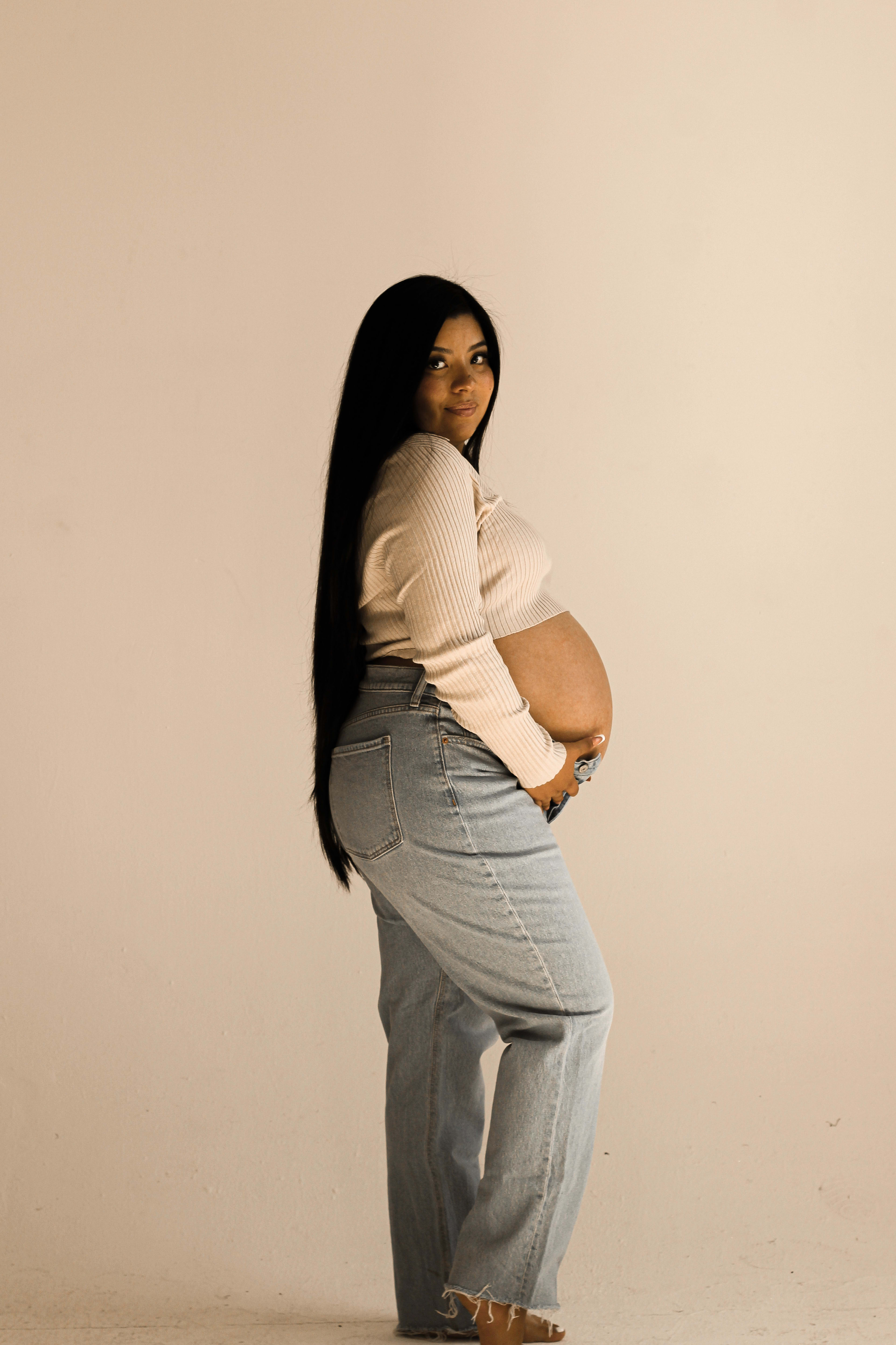 A beige maternity photo shoot of a pregnant woman.