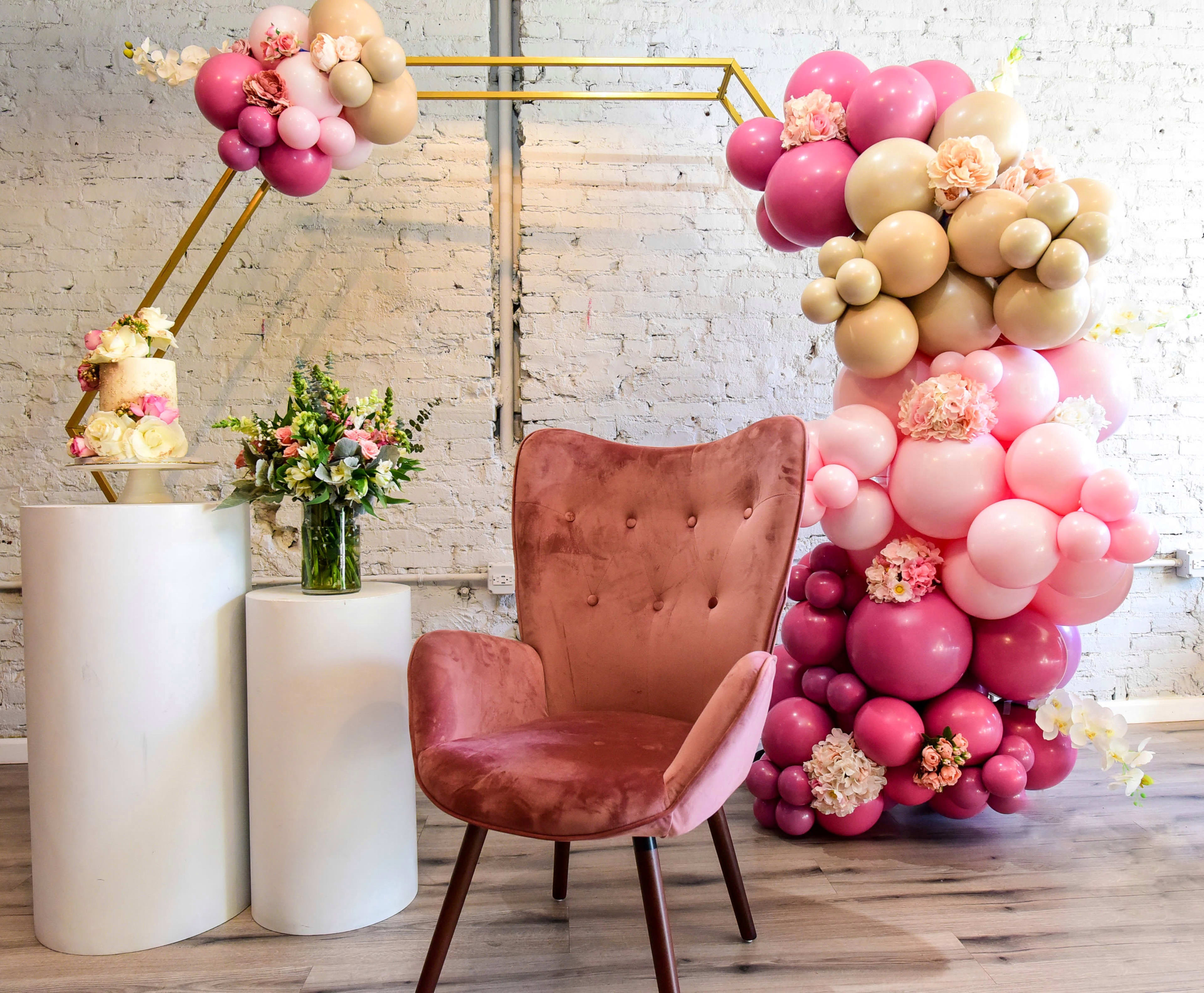Ein rosa Stuhl inmitten von Ballons bei einer Brautparty.