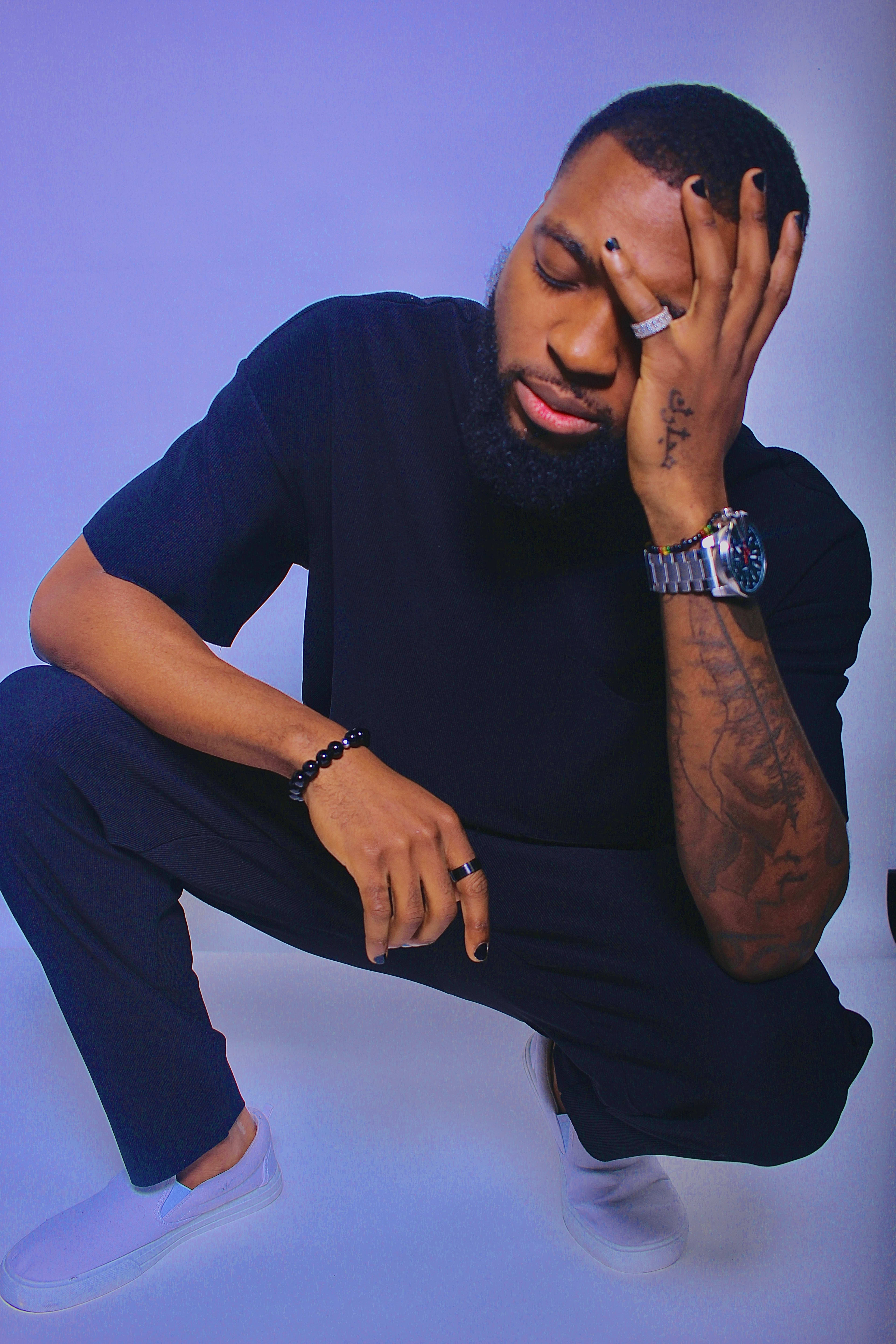 A man with a few rings and watch poses for a photo shoot.