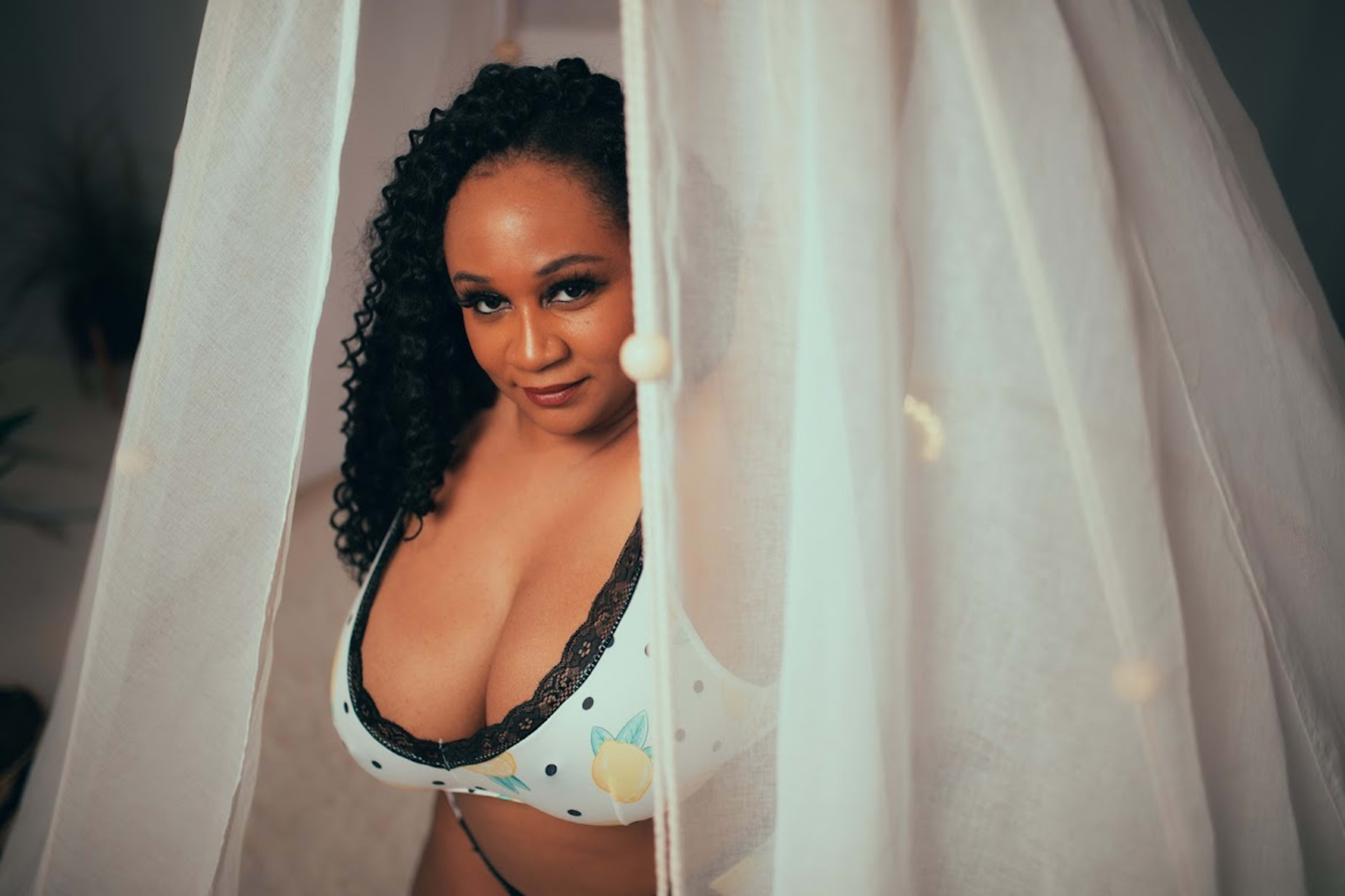 Une femme en lingerie posant pour un shooting photo boudoir.