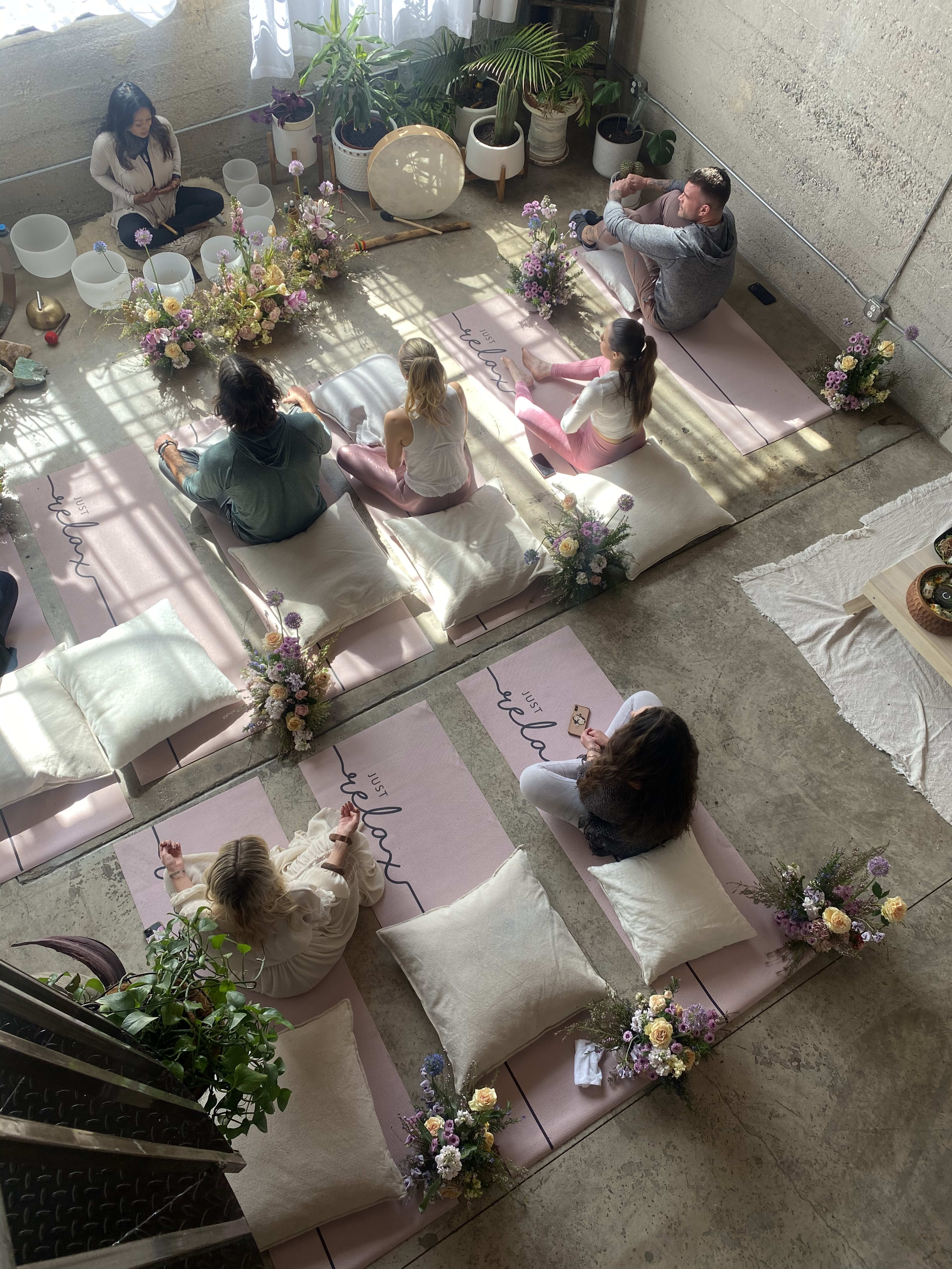 A group of people sitting at a rustic table with flowers on it.