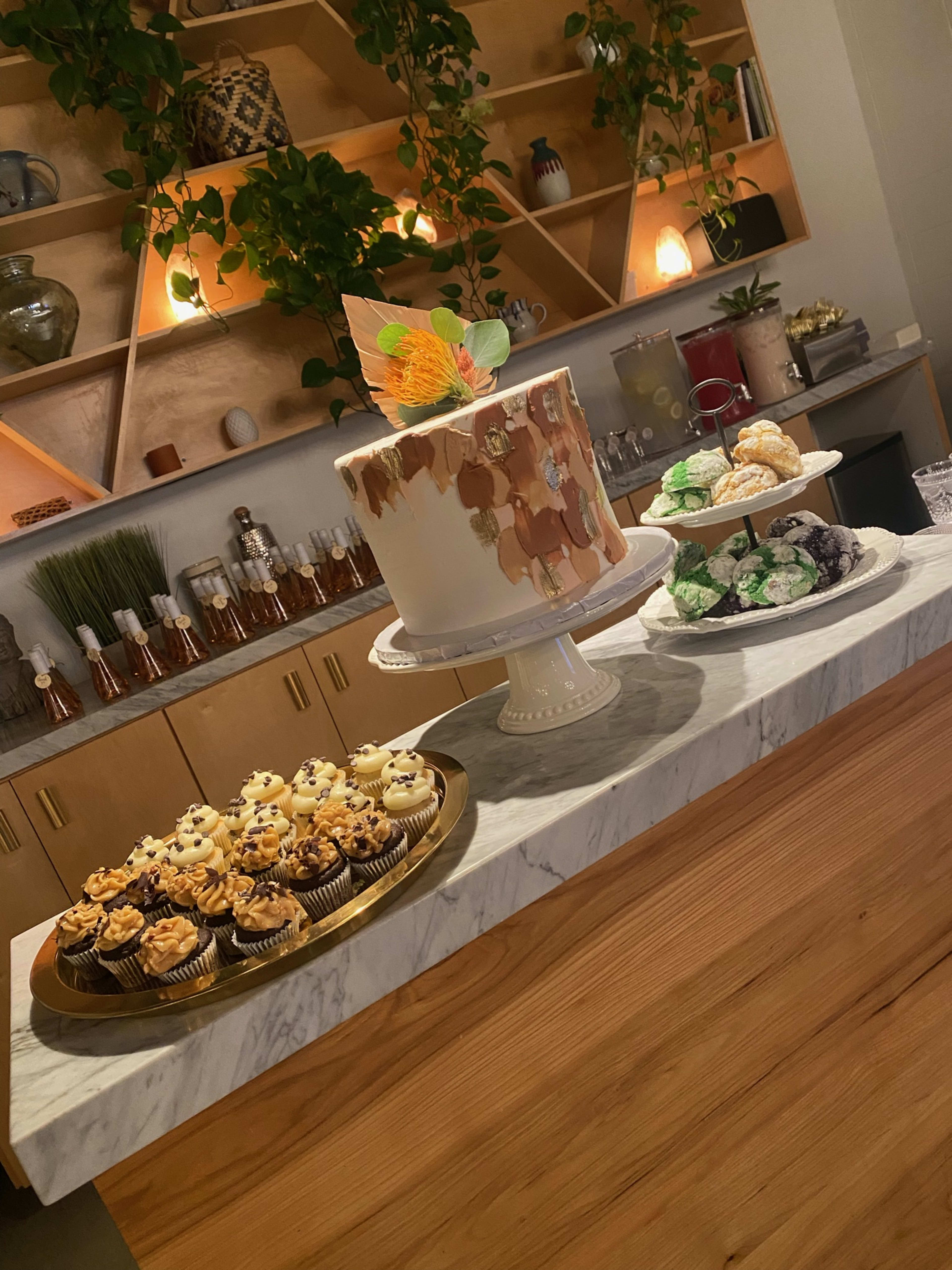 Una mesa rústica con cupcakes y tartas marrones y verdes, perfecta para una despedida de soltera.