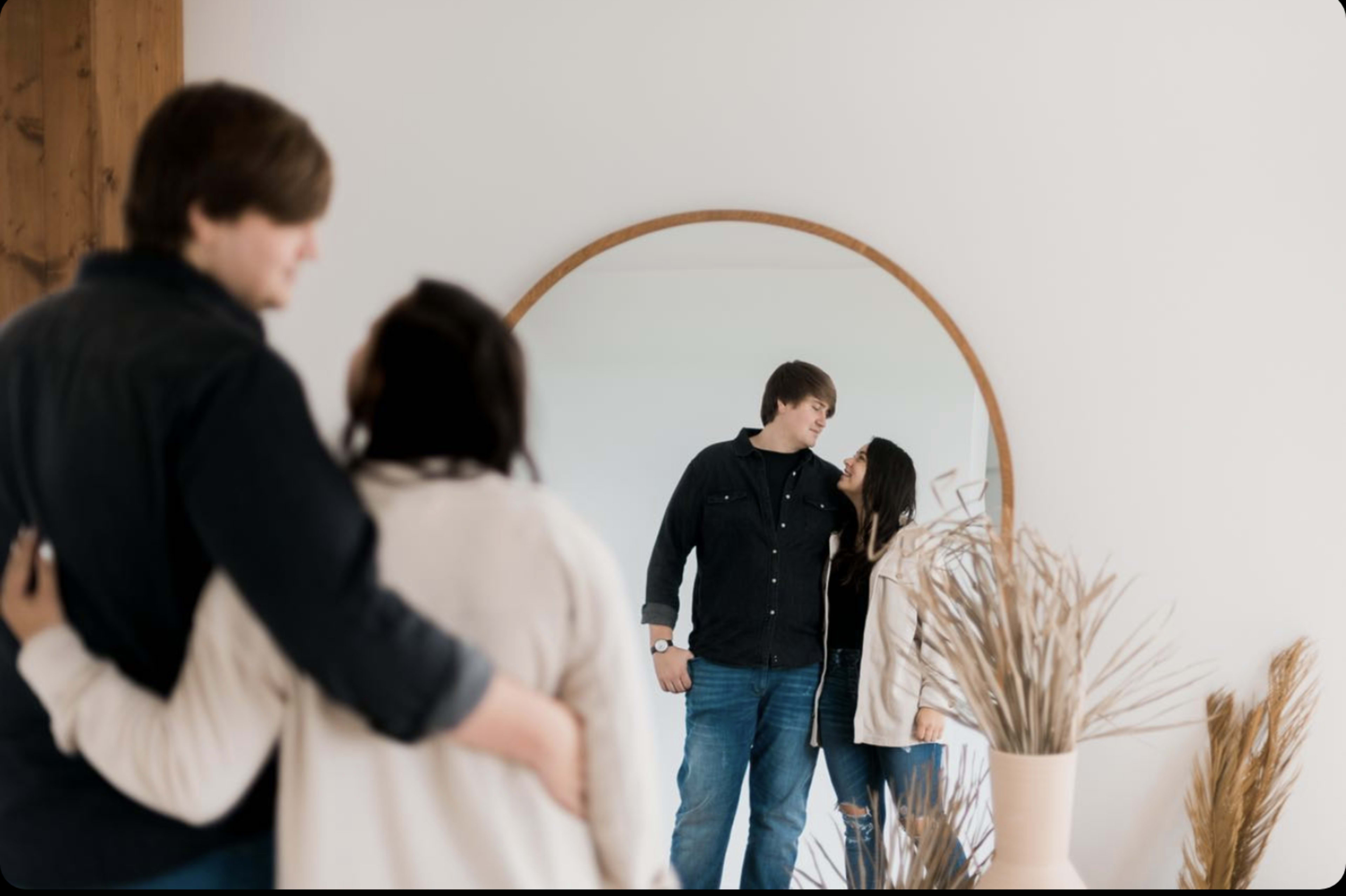 A couple posing in front of a mirror for a boho theme photoshoot.