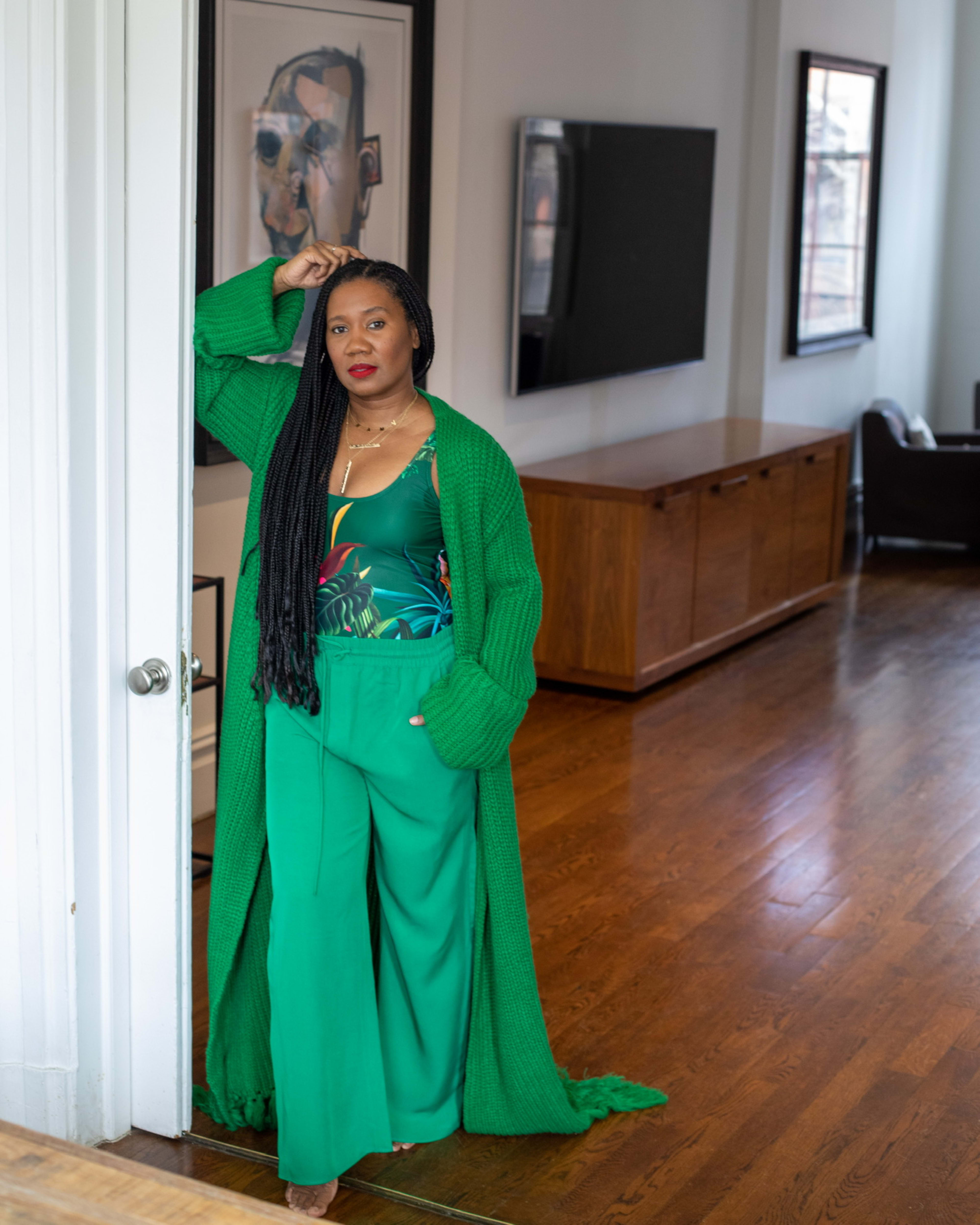 Una modelo de ropa con un conjunto verde posando para una sesión de fotos.