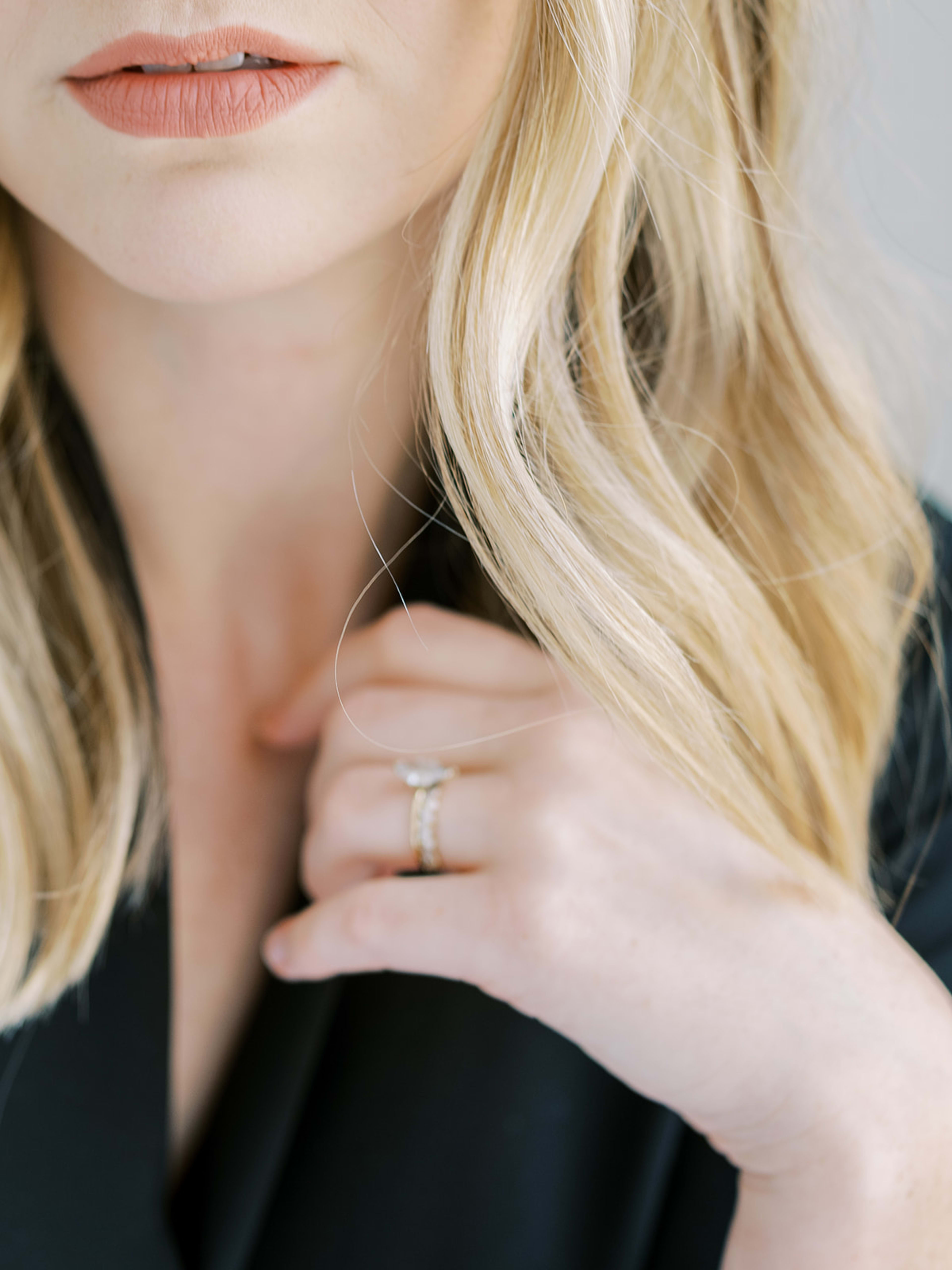 A woman with a ring on her finger during a photoshoot.