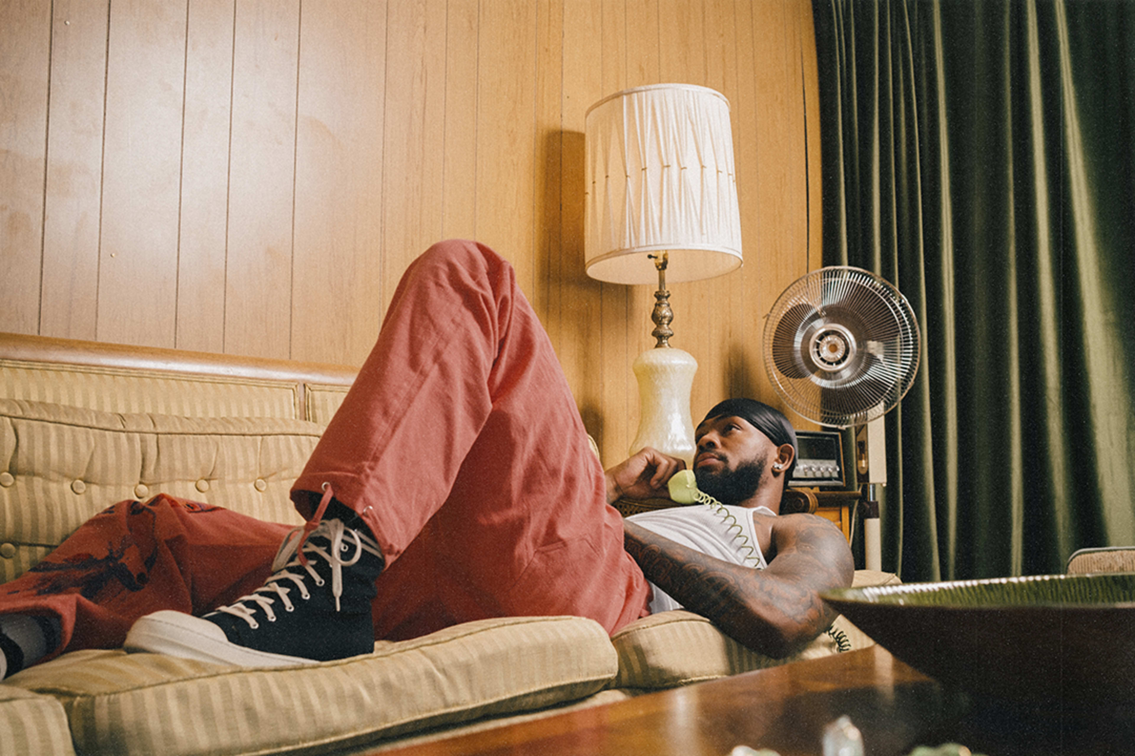 A retro photo shoot of a man sitting on a couch.