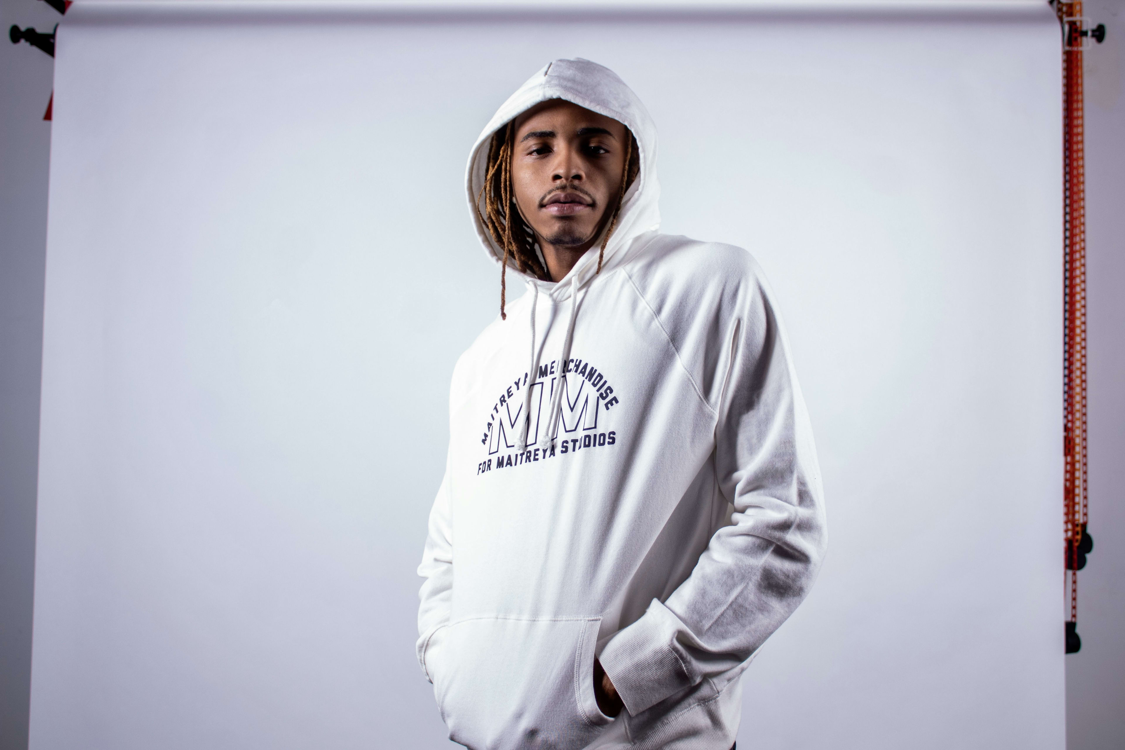 A man in a white hoodie during a photoshoot.