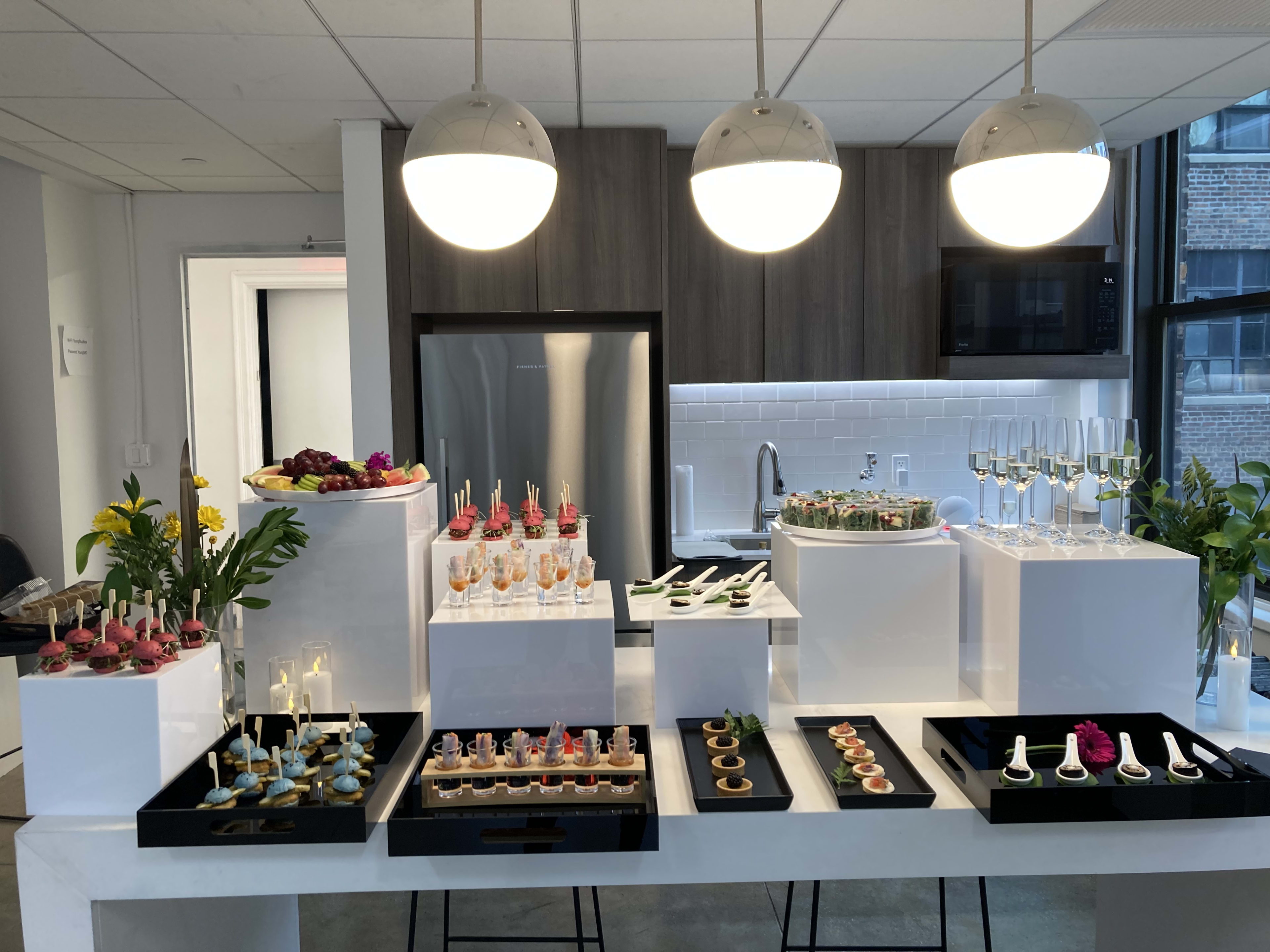 A food photo shoot with a white table topped with lots of trays of food.