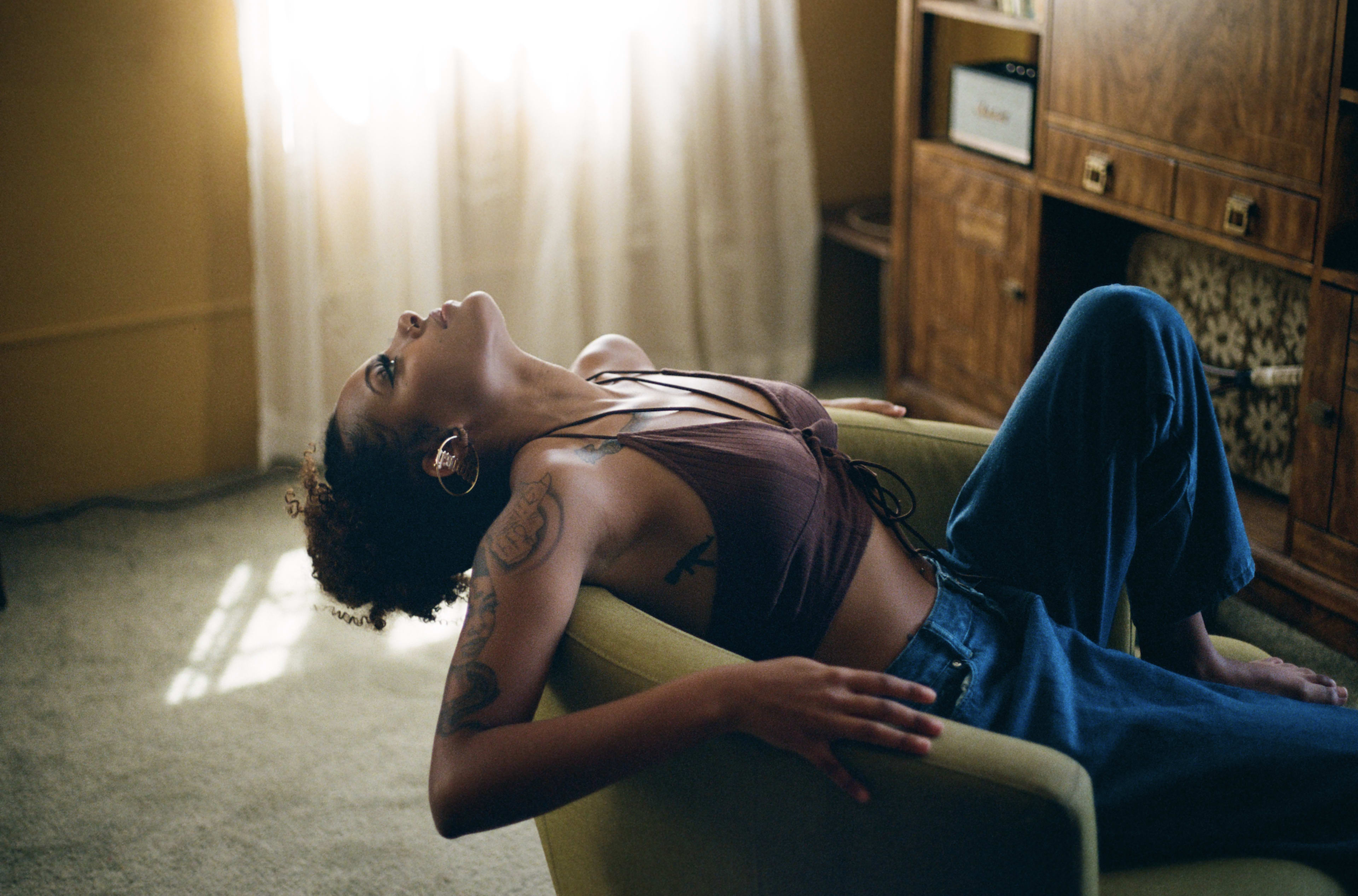 Un mannequin posant sur une chaise pendant un shooting photo.