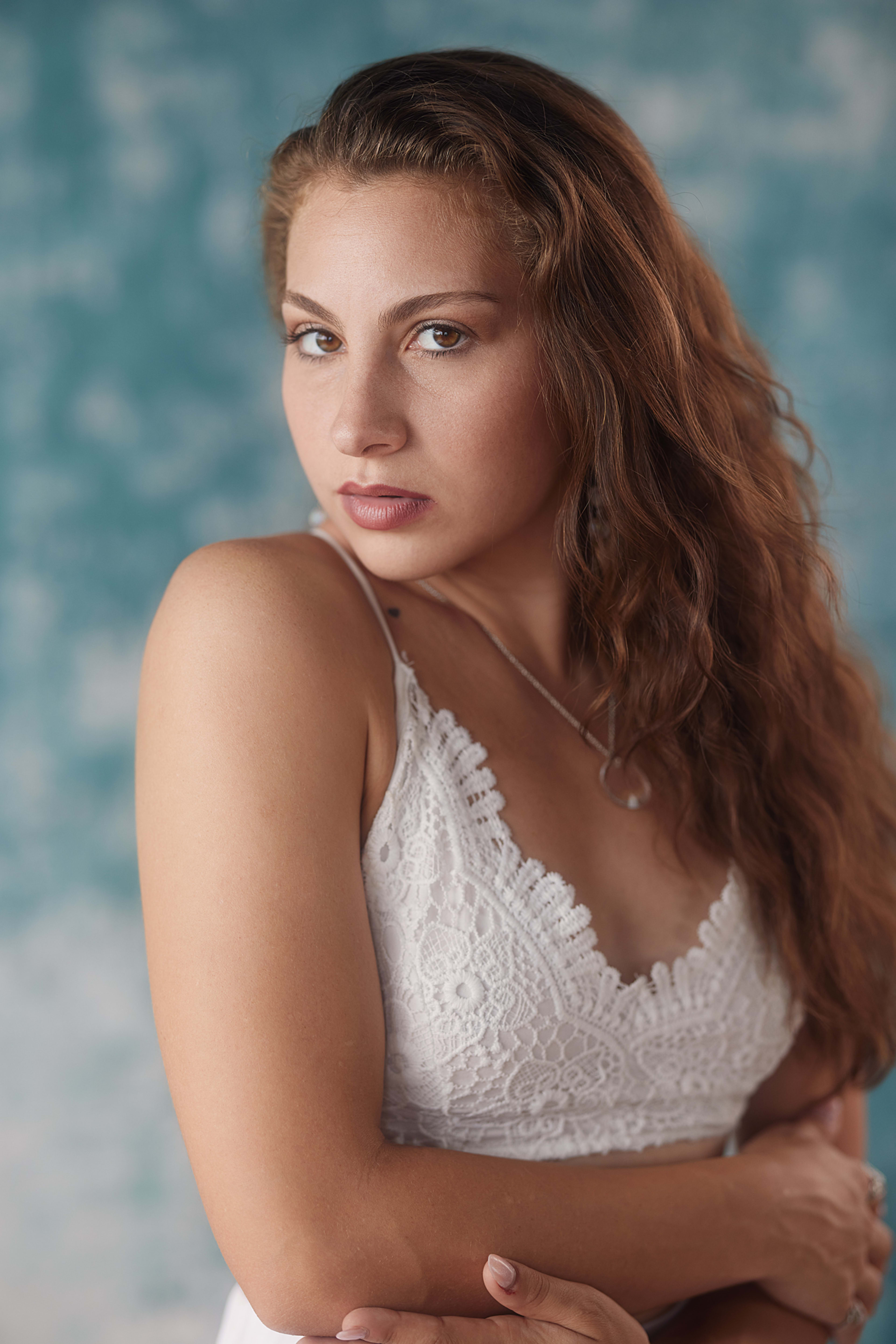 A woman in a white dress posing for a boho portrait.