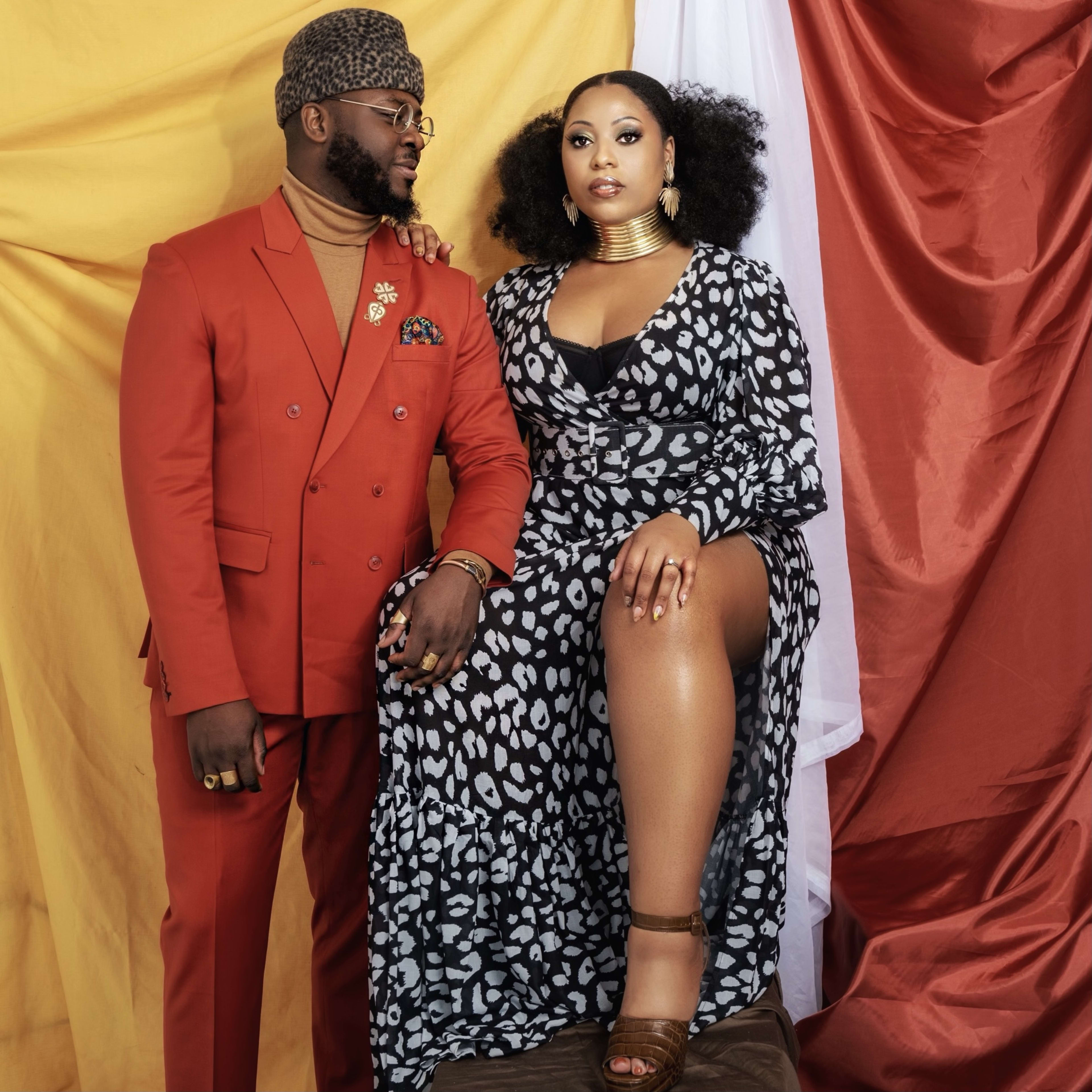 A couple next to each other in a yellow- and red-themed photo shoot.