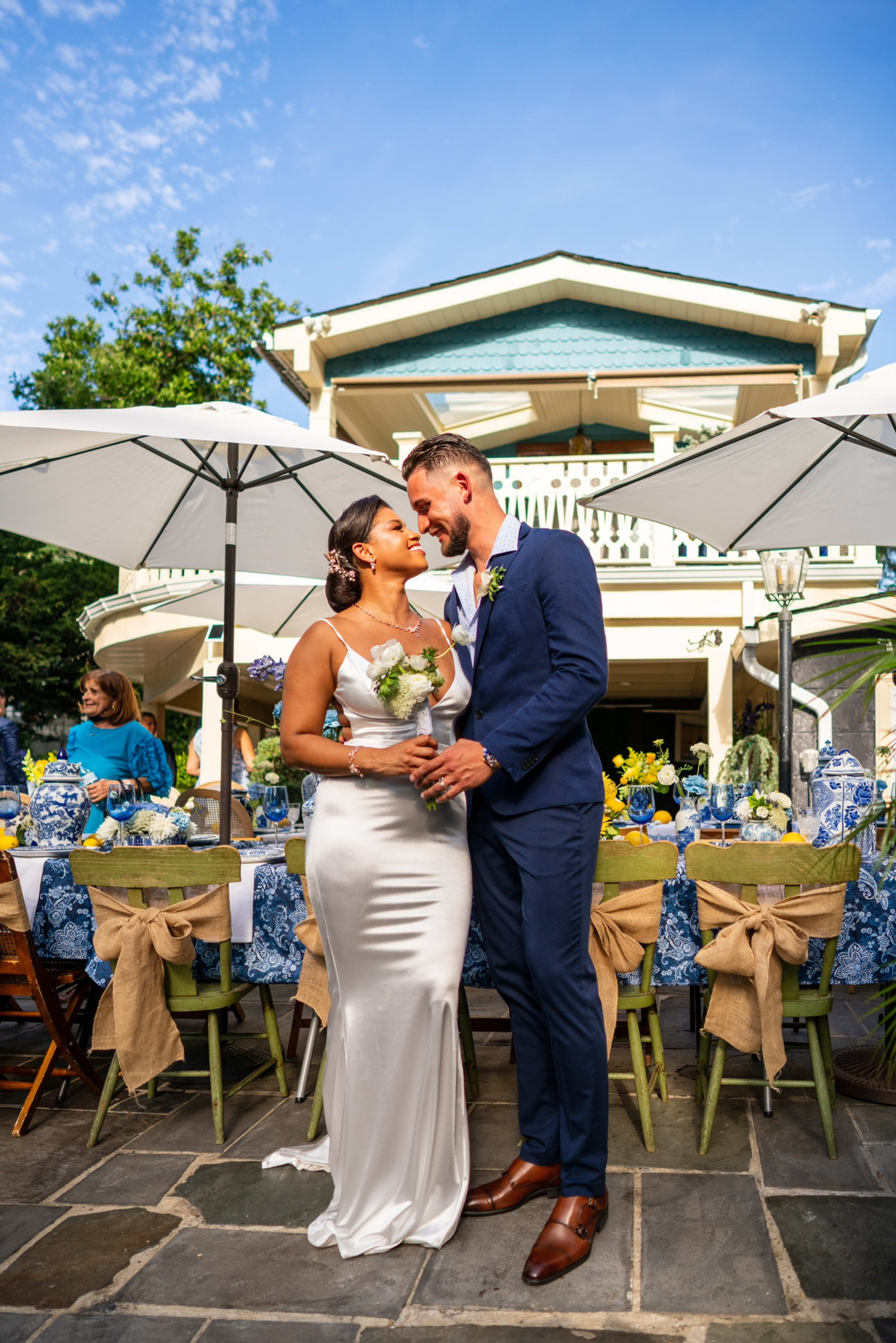 A bride and groom standing in front of an outdoor garden.