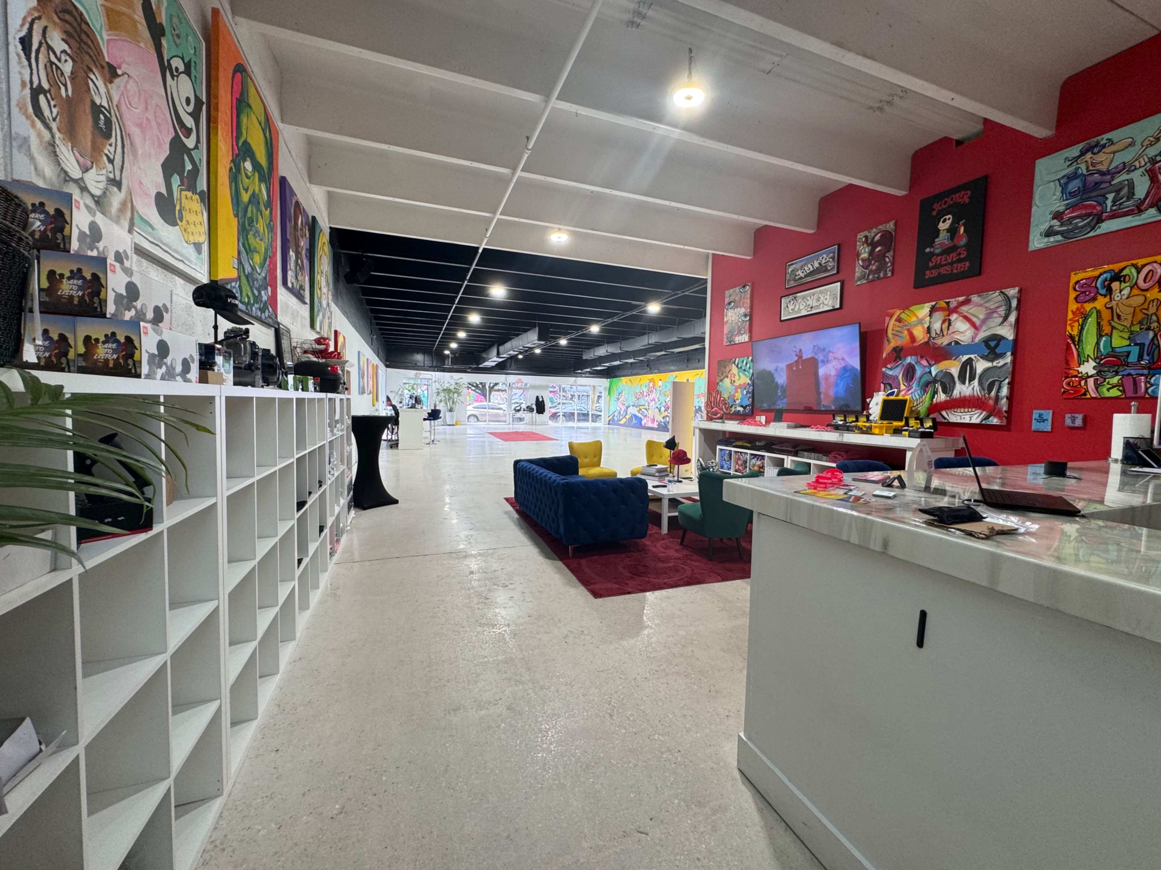 A spacious, brightly decorated interior featuring colorful murals on the walls, a modern seating area, and various artistic elements throughout the space.