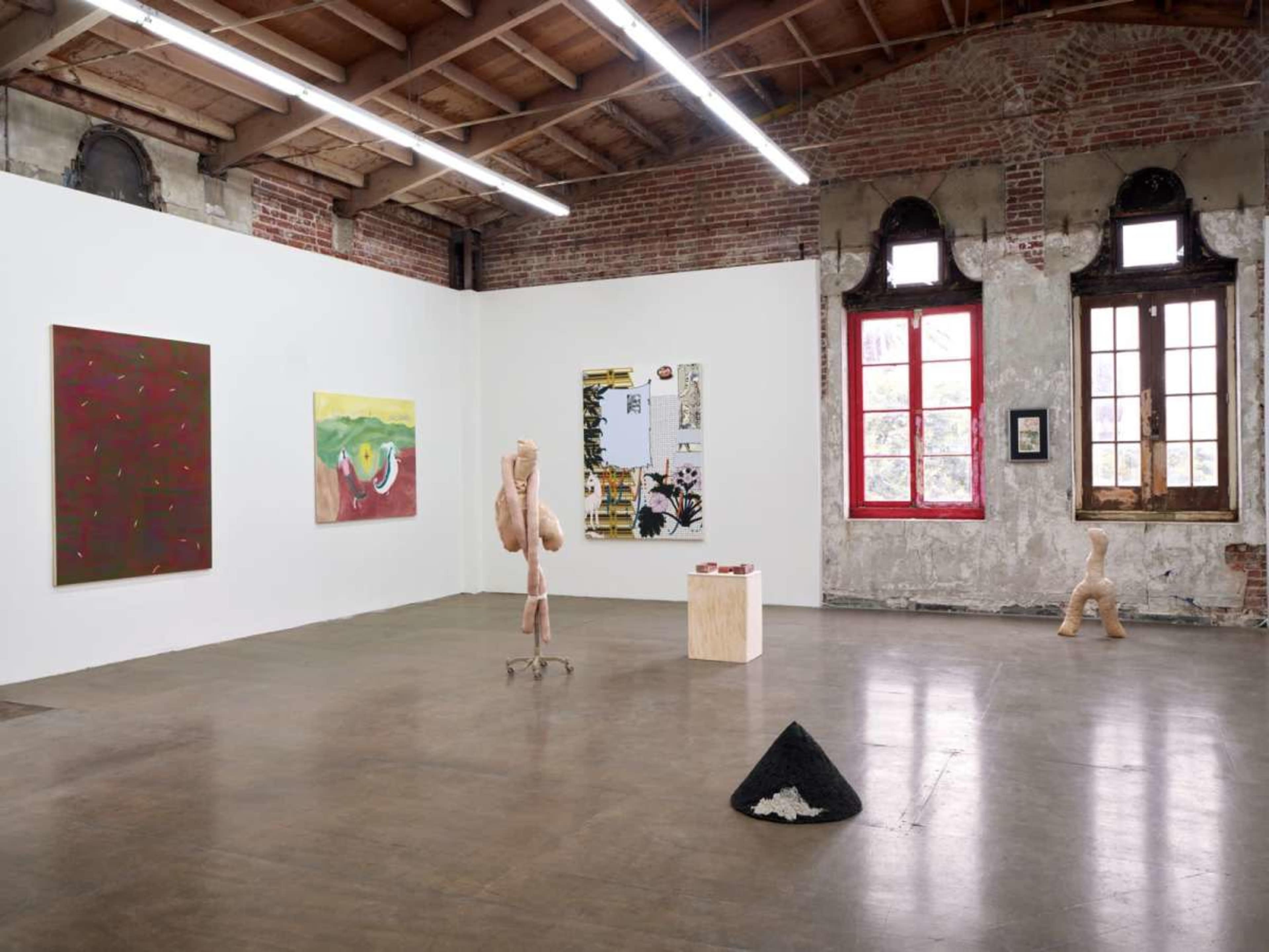 An art gallery with two abstract paintings on the white walls, a sculpture in the center, and a display of various art materials on a wooden pedestal.