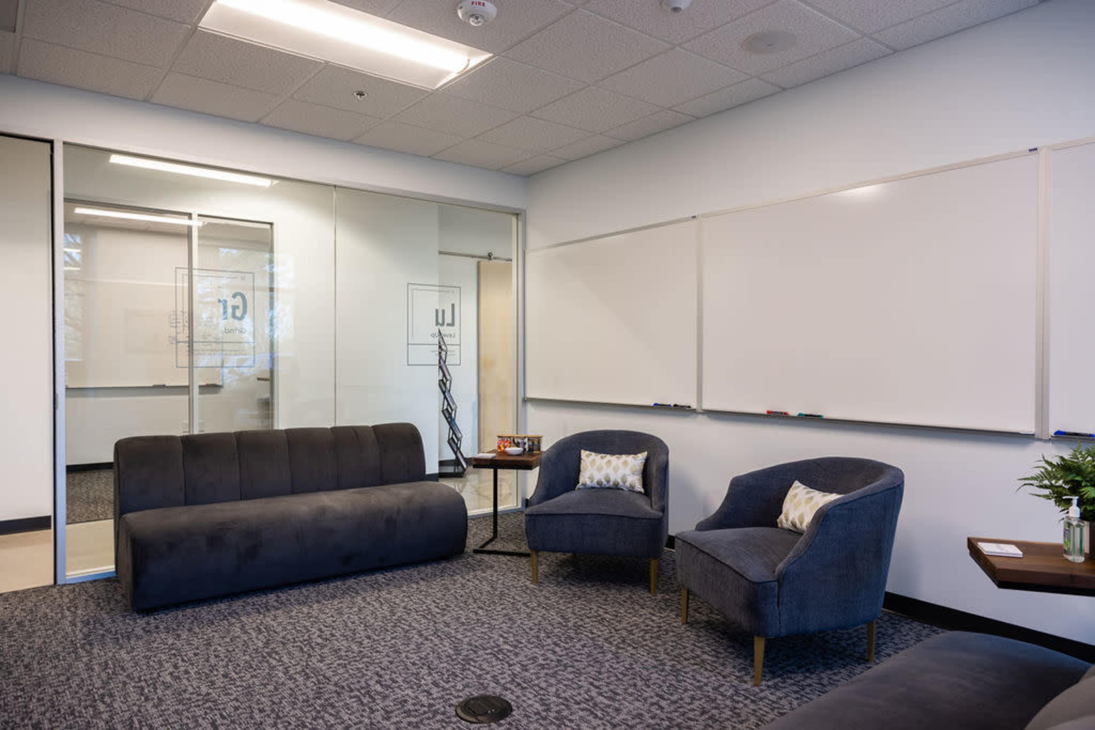 Premium meeting rooms in convenient location. Floor-to-ceiling windows, custom standing-height natural wood tables, Herman Miller® Aeron chairs, 600+ feet of whiteboards, easy-to-use AV technology including large flat-screen monitors and 360° Meeting Owl Cameras. Vast array of snacks (includes ice cream!), 60+ beverages, premium coffee, and concierge-level service. Just 7 minutes from RDU Airport with free parking. Image in Umstead, Raleigh, NC