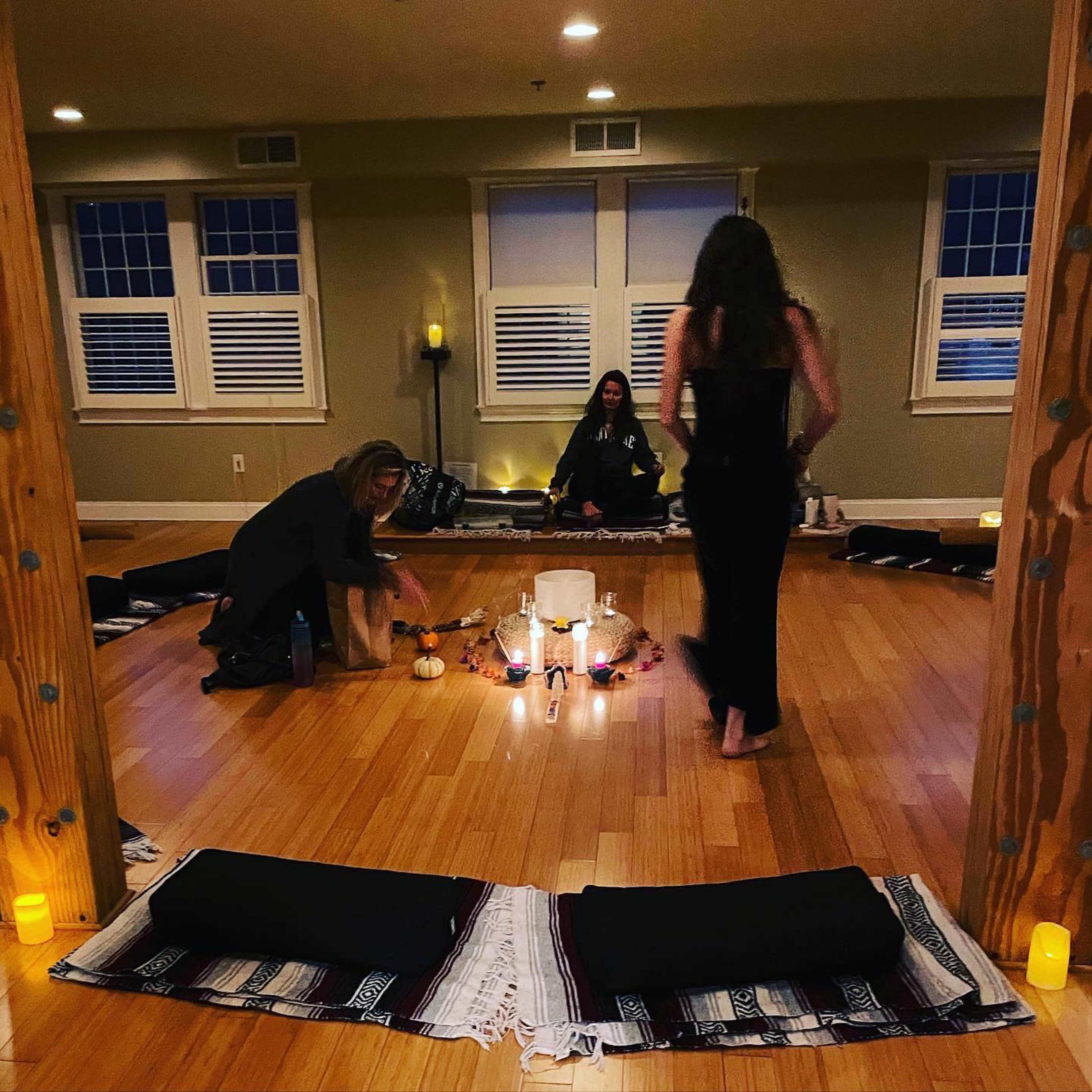 A serene yoga or meditation space with mats laid out, candles lit, and participants engaged in a calming activity.