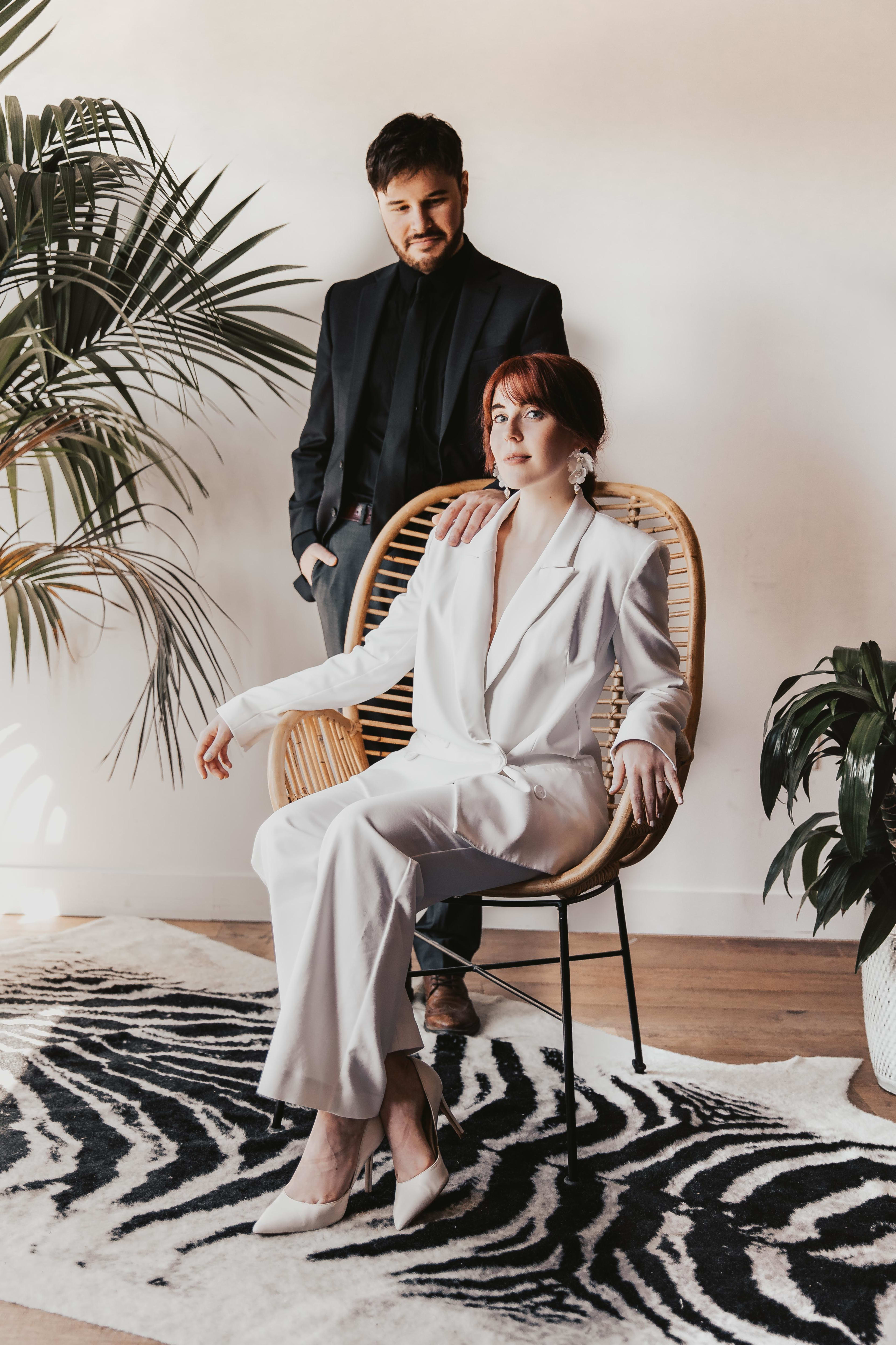 A couple sitting on a chair during a boho photoshoot.